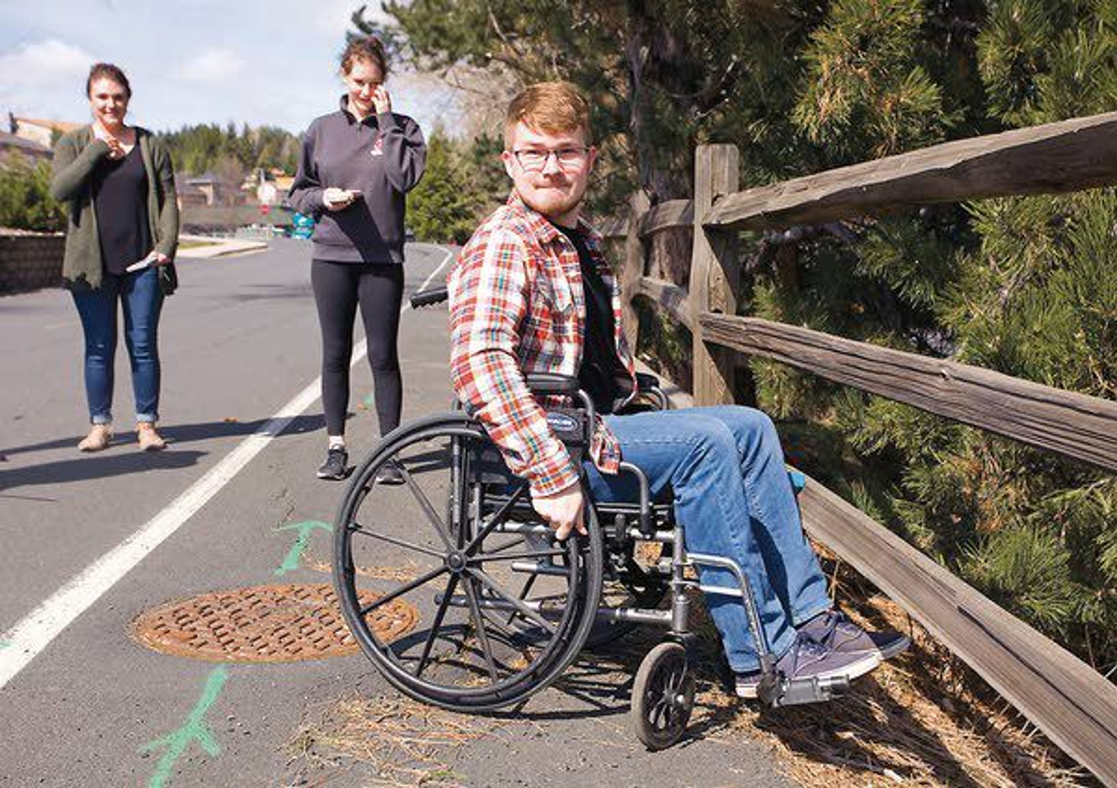 Washington State University student Zack Malmberg tries to negotiate uneven pavement using a wheelchair while classmates Natalie Swanson, left, and Hayley Sandberg watch Friday in Pullman. The students were helping to map Pullman businesses for accessibility to people with disabilities.