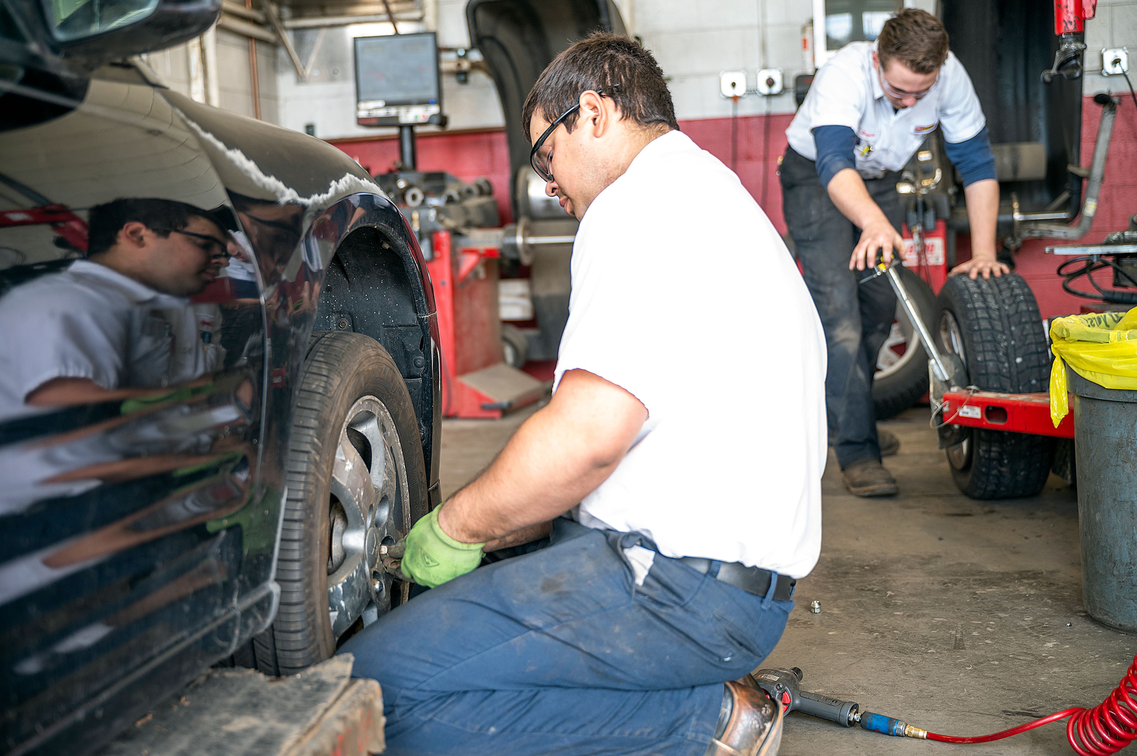 Les Schwab Tires employees Sandy Warn (left) and Bryce Yates work on replacing snow tires on a vehicle on Tuesday afternoon at the shop on Thain Road in Lewiston.