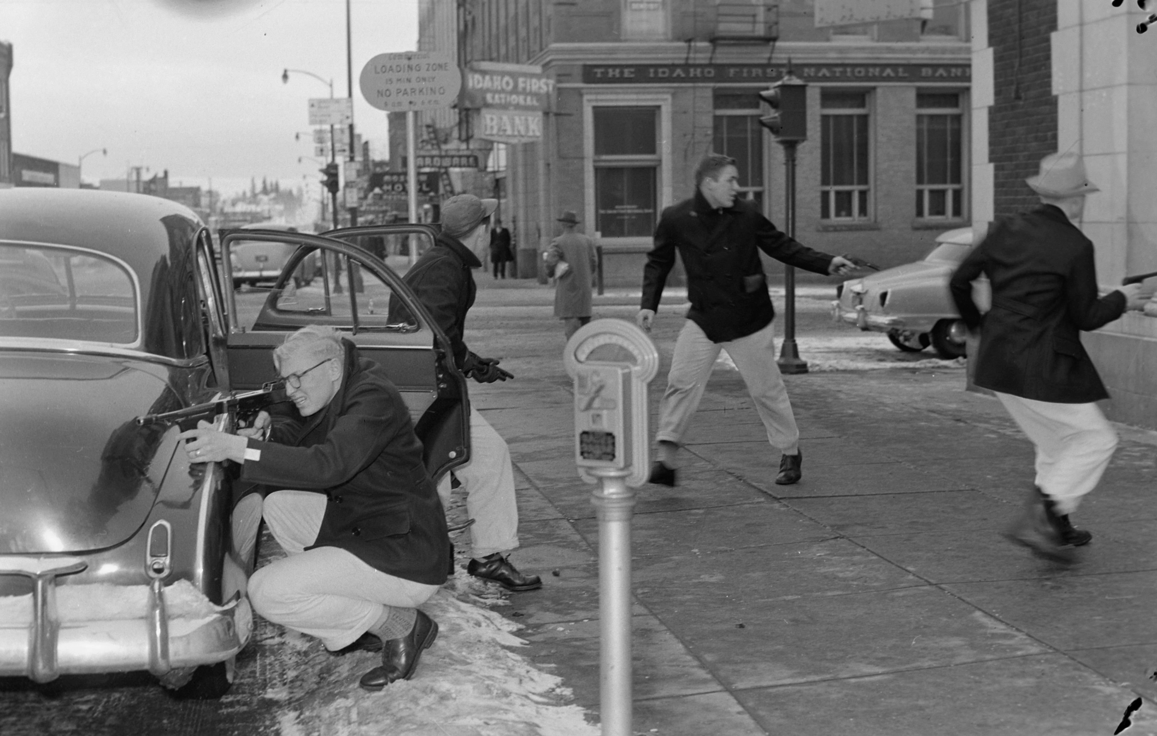  �Robbers� are pictured in a staged bank robbery outside the First Trust & Savings Bank at Third and Main Streets circa 1948-52.