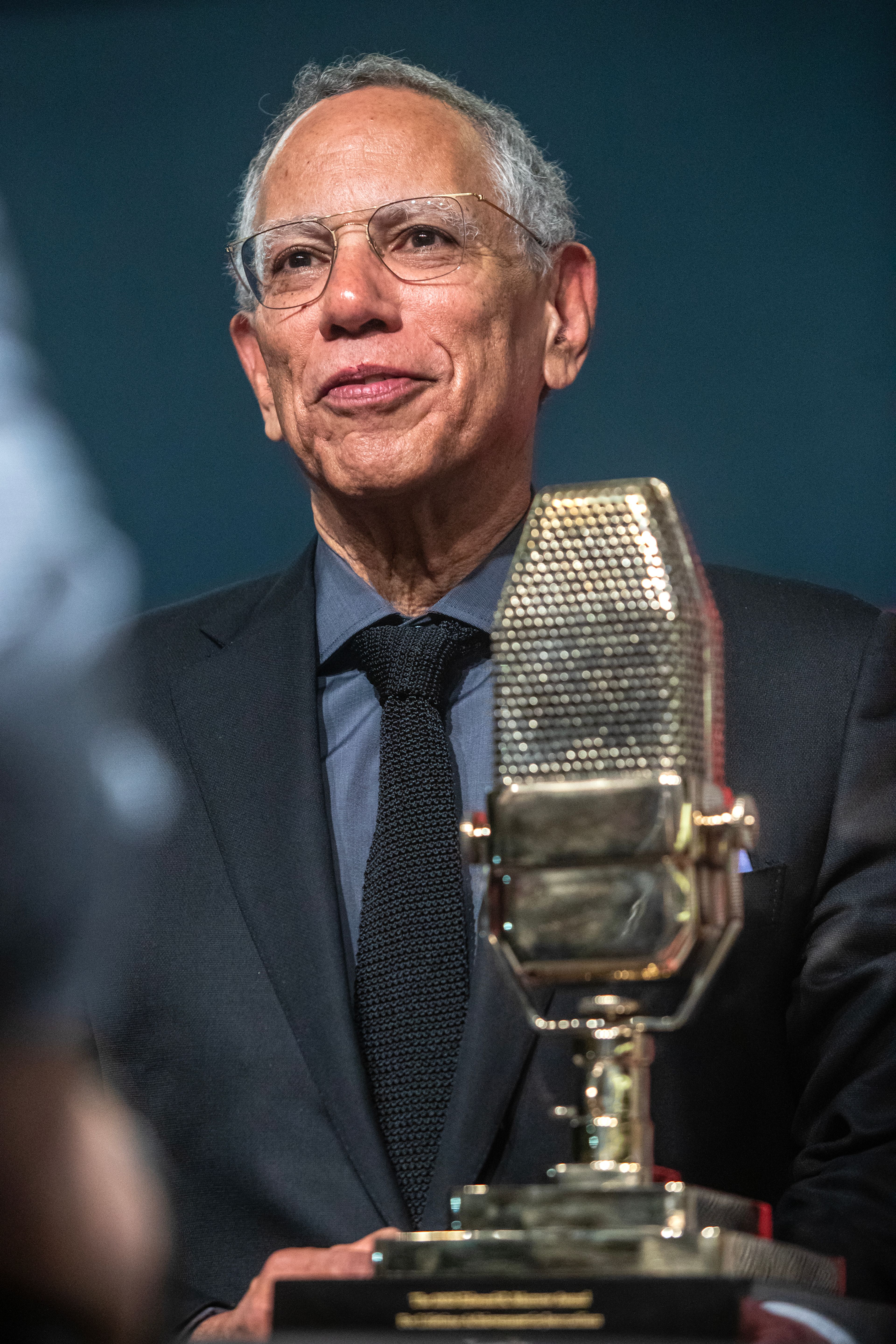 Dean Baquet stands next to his Lifetime Achievement Award at the Murrow Symposium Tuesday in Pullman.