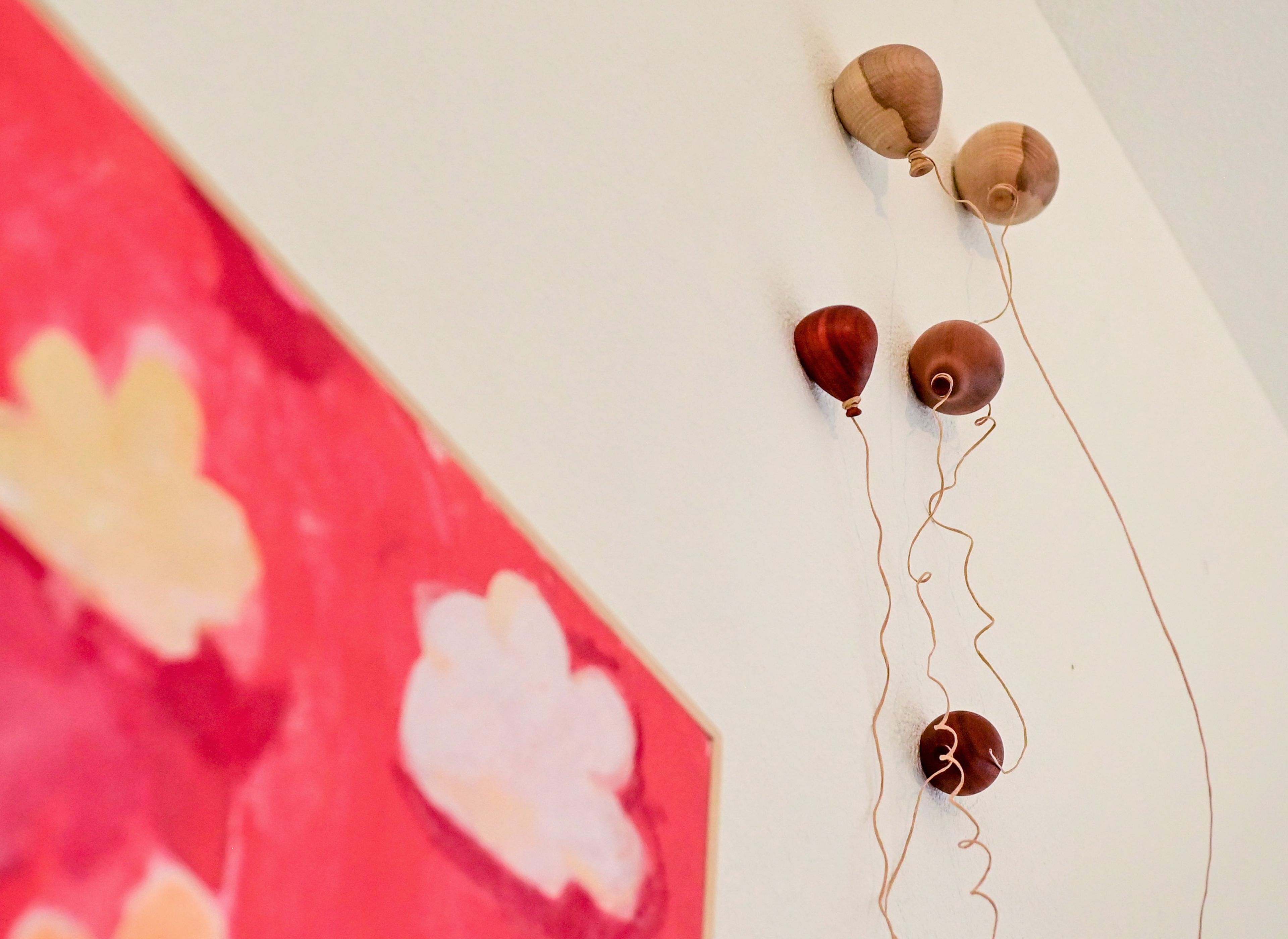 Wooden balloons created by Noah Schuerman hang along the wall of the Little Pink House Gallery as part of the gallery’s upcoming show, Ten, in Genesee on Thursday.