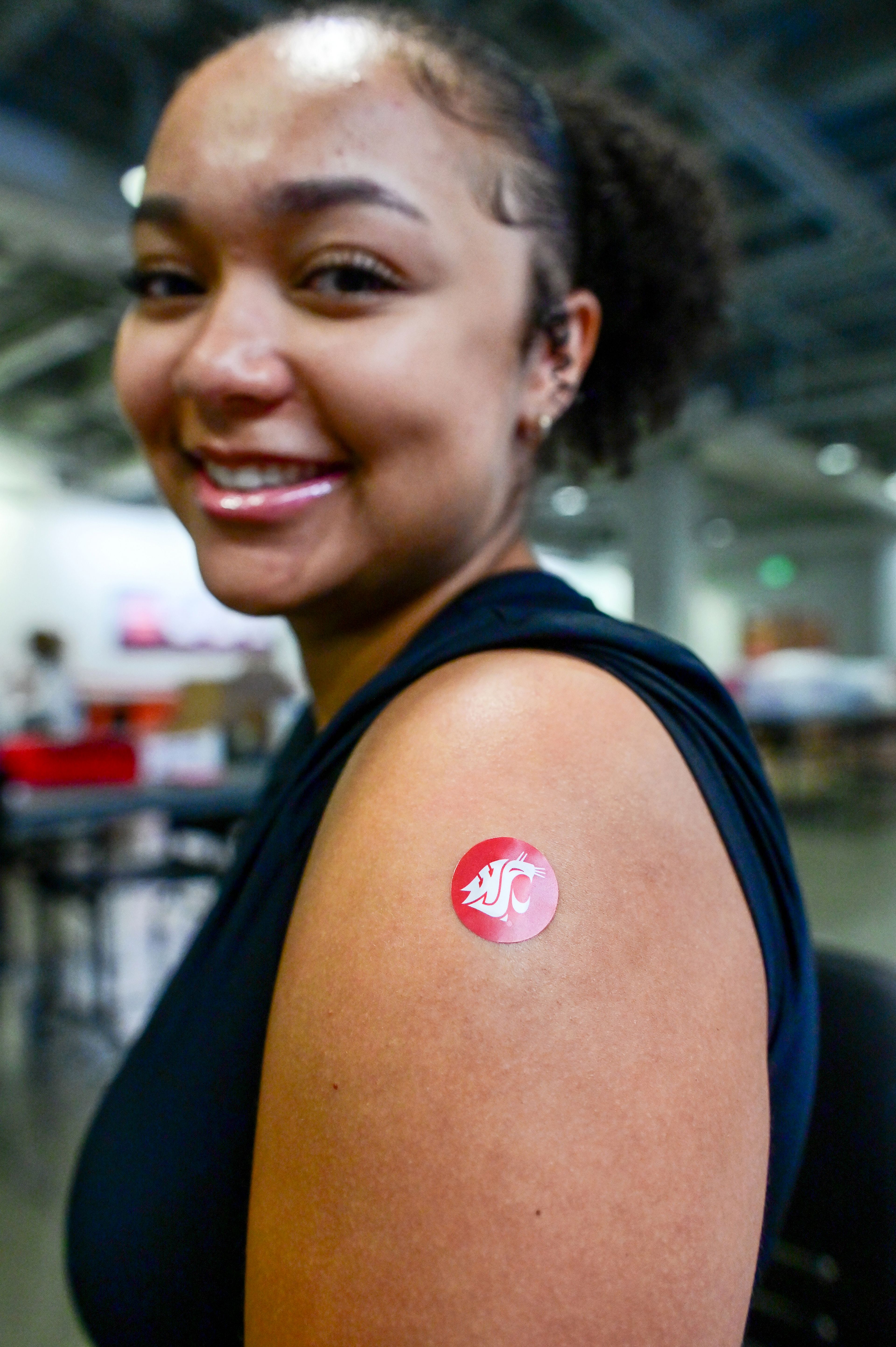 A small bandage with the Washington State University Cougar logo is placed on the arm of Sierra Rowe, a WSU student and secretary of the Student Health Advisory Council with Cougar Health Services, after Rowe received a flu vaccine Friday at the Flu Shot Friday clinic on campus in Pullman.