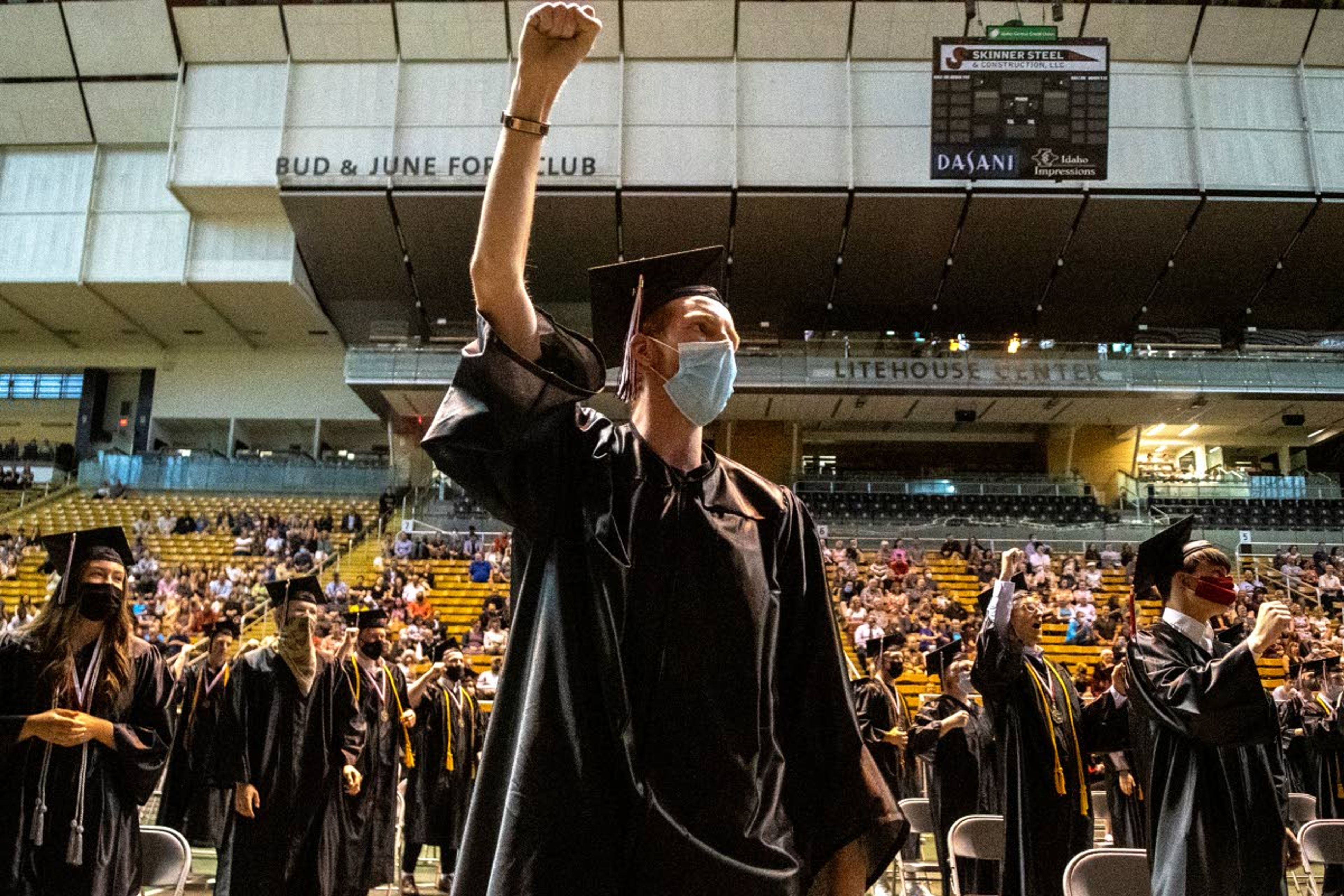 Zach Wilkinson/Daily NewsABOVE: Graduating seniors stand and perform the Moscow High School fight song during their commencement at the University of Idaho’s Kibbie Dome on Friday night. BELOW: Graduating seniors toss their caps into the air at the end of their commencement.