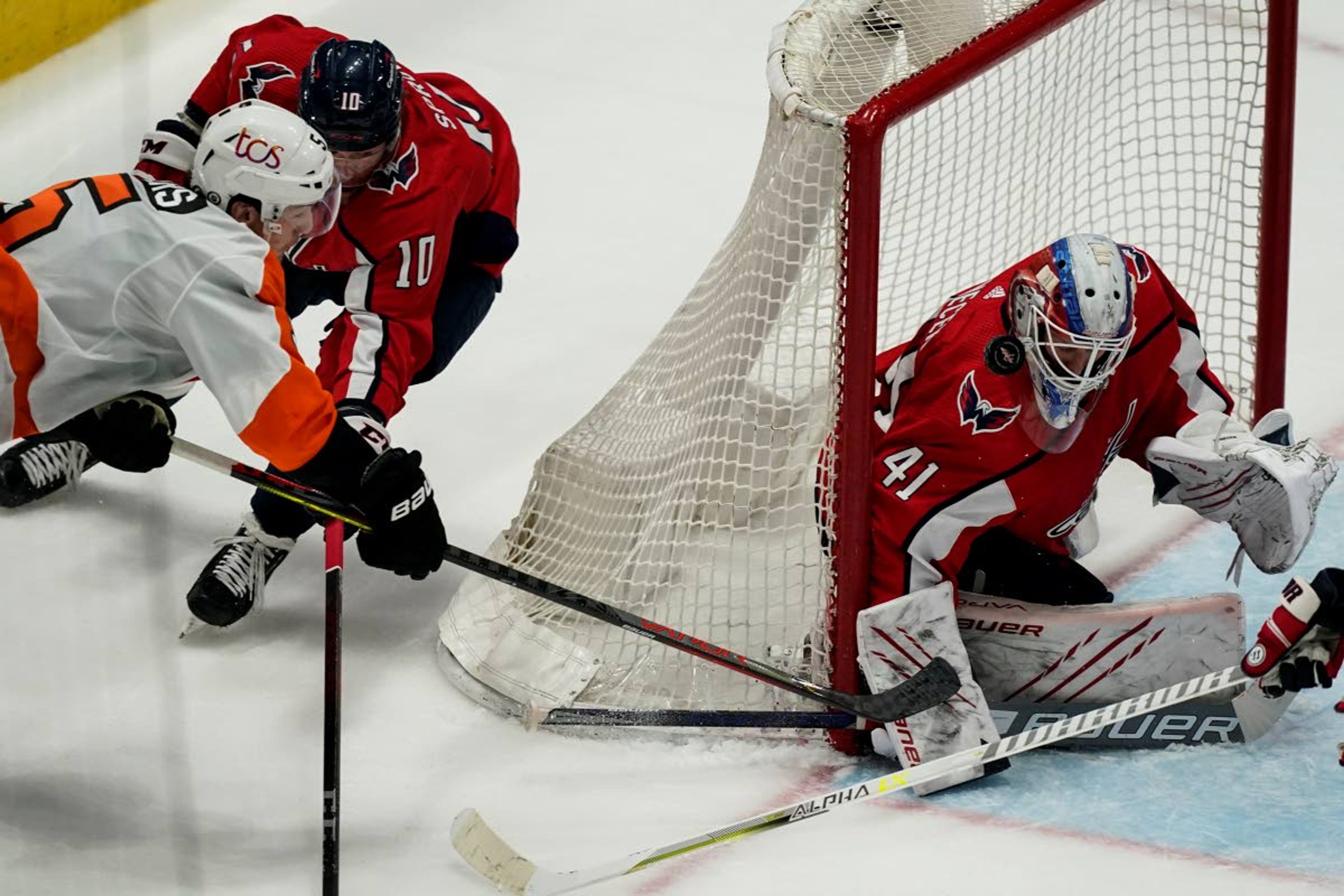 Philadelphia Flyers defenseman Philippe Myers (5) shoots as Washington Capitals right wing Daniel Sprong (10) defends with Washington Capitals goaltender Vitek Vanecek (41) during the second period of an NHL hockey game, Friday, May 7, 2021, in Washington. (AP Photo/Alex Brandon)