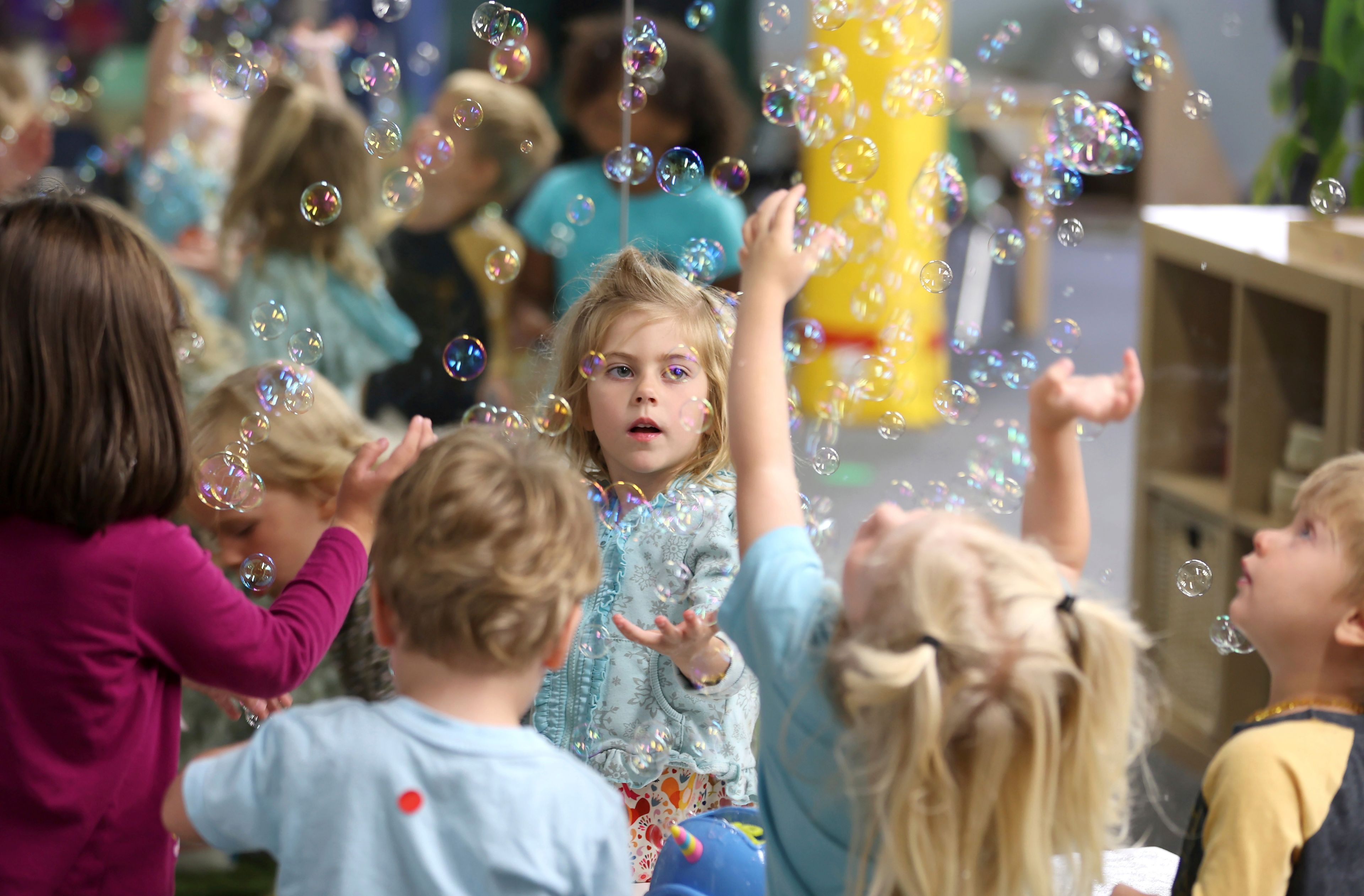 Lova Robinson, 4, plays with bubbles at the Bumble Art Studio day care in Astoria, Ore., Friday, Sept. 2, 2022. From Oregon to New York, demand for child care far exceeds supply. Families are growing increasingly desperate as providers deal with staffing shortages exacerbated by the coronavirus pandemic as well as historically low pay worsened by inflation. (AP Photo/Craig Mitchelldyer)