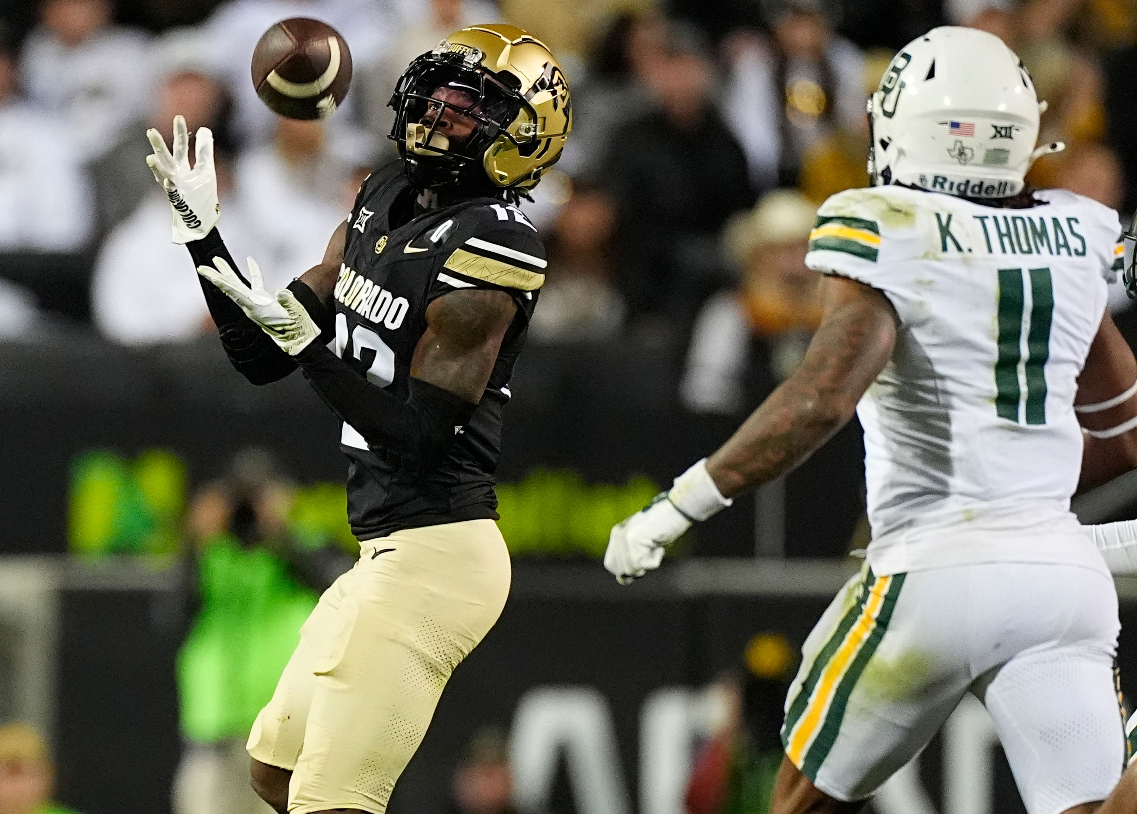 Colorado wide receiver Travis Hunter, left, pulls in a pass as Baylor linebacker Keaton Thomas defends in the second half of an NCAA college football game Saturday, Sept. 21, 2024, in Boulder, Colo. (AP Photo/David Zalubowski)