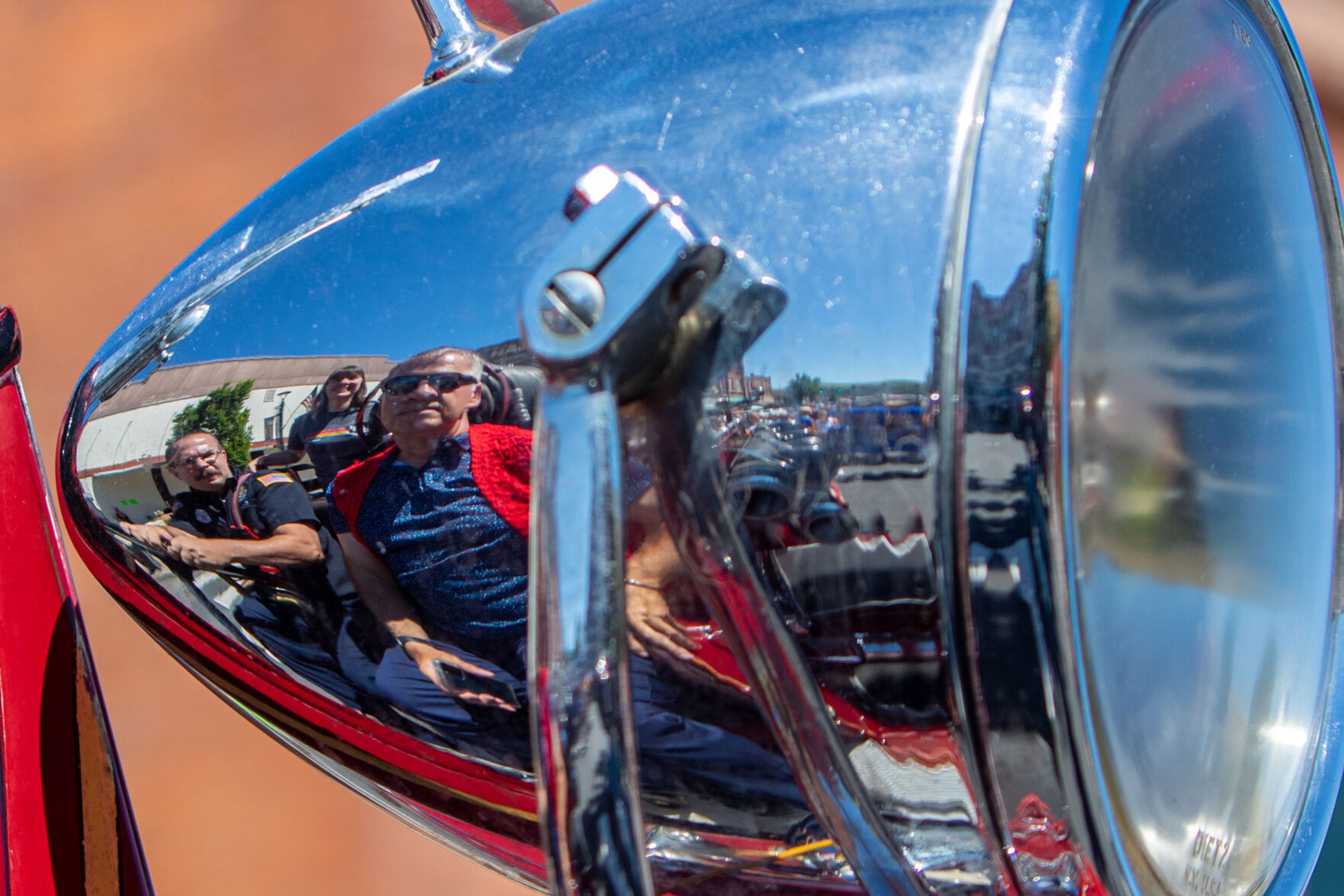 Colfax Mayor James Retzer reflects off the headlight of an early 20th century fire truck Saturday as the truck leads the children’s parade during the city’s 150th birthday celebration.