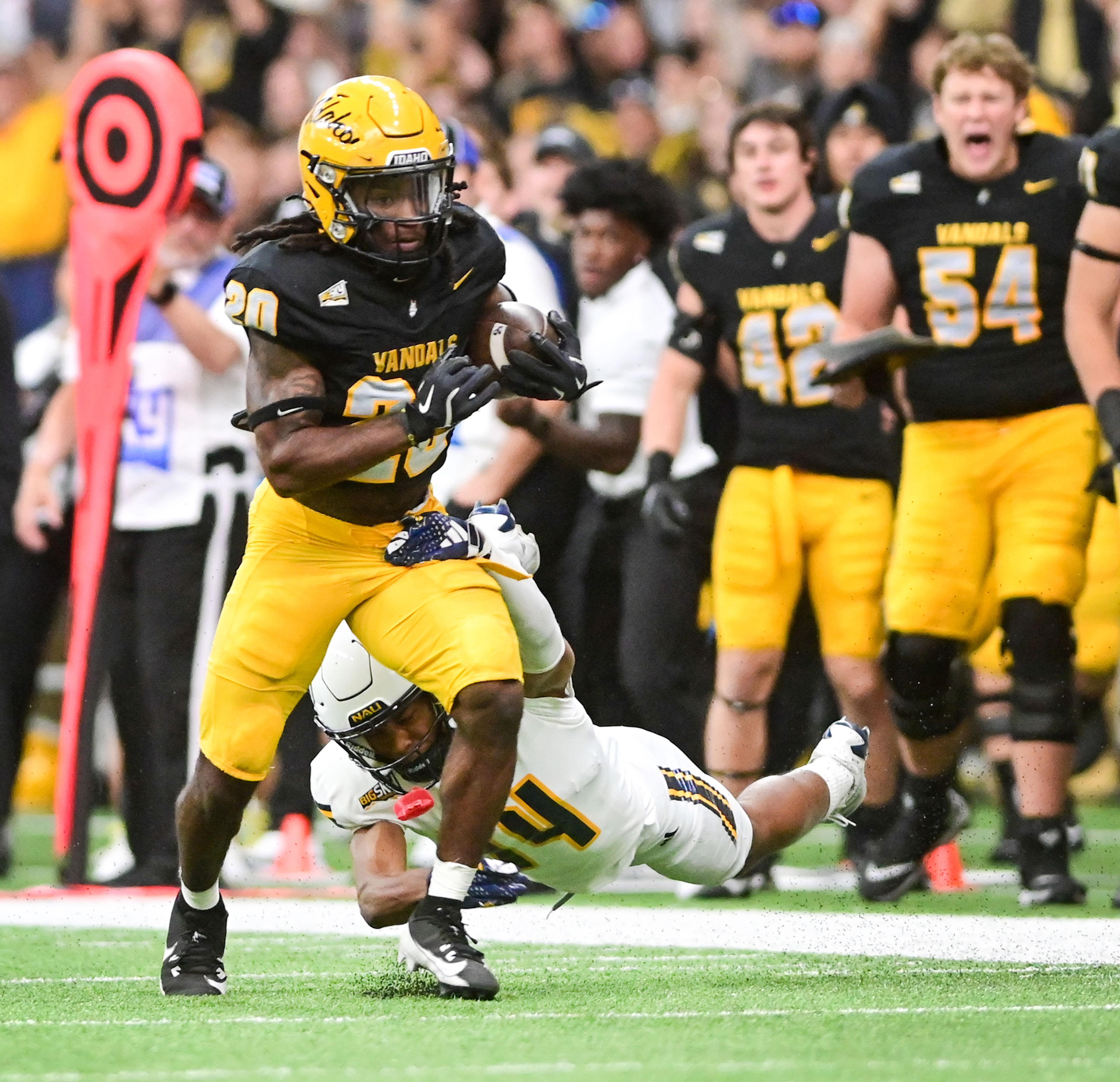 Idaho running back Elisha Cummings breaks free from a tackle attempt by Northern Arizona defensive back Tim Williams Saturday at the P1FCU Kibbie Dome in Moscow.,