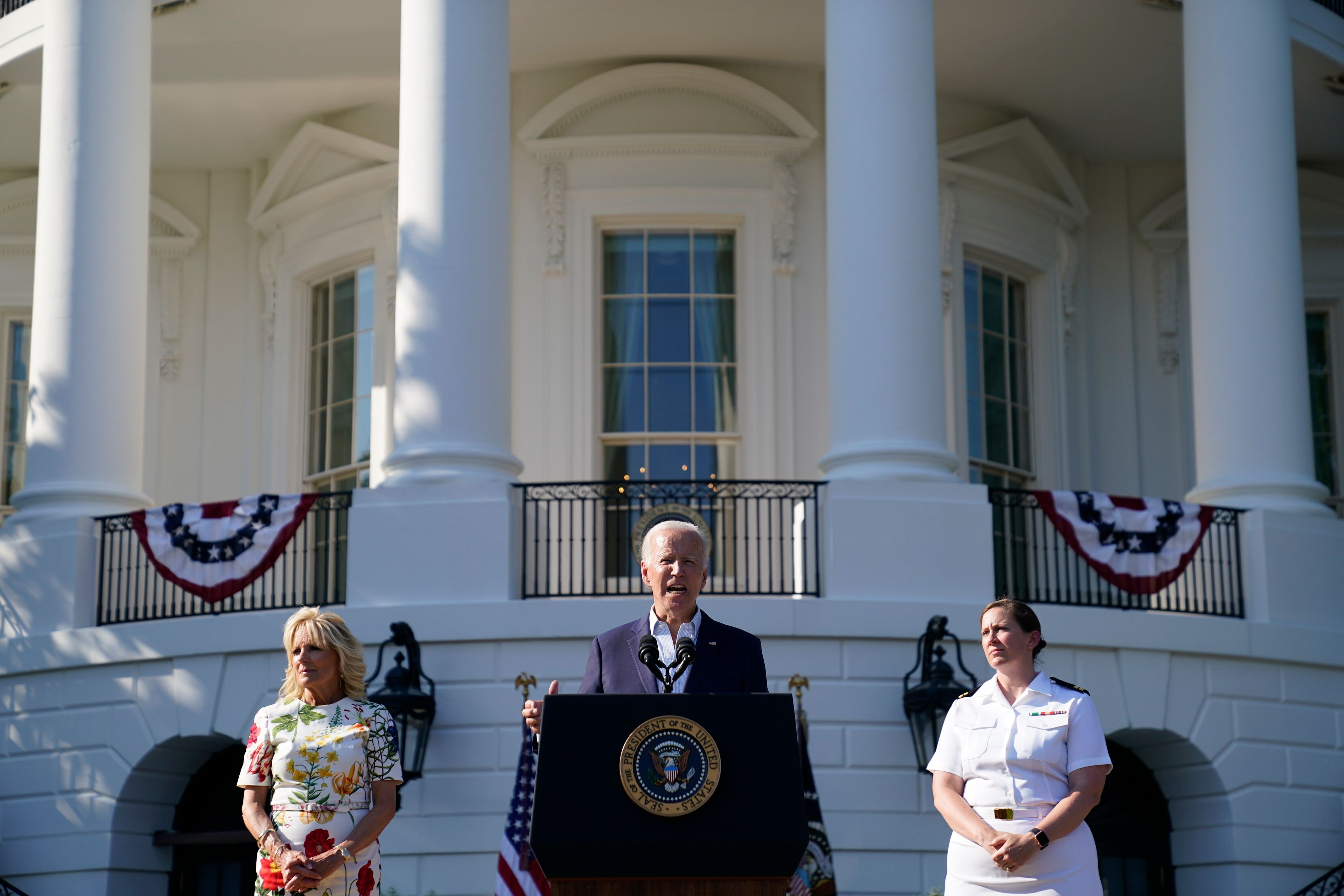 President Joe Biden gesture after speaking at a Fourth of July celebration for military families on the South Lawn of the White House, Monday, July 4, 2022, in Washington. Listening are first lady Jill Biden, left, and Navy Chaplain Lt. Chandler Irwin. (AP Photo/Evan Vucci)