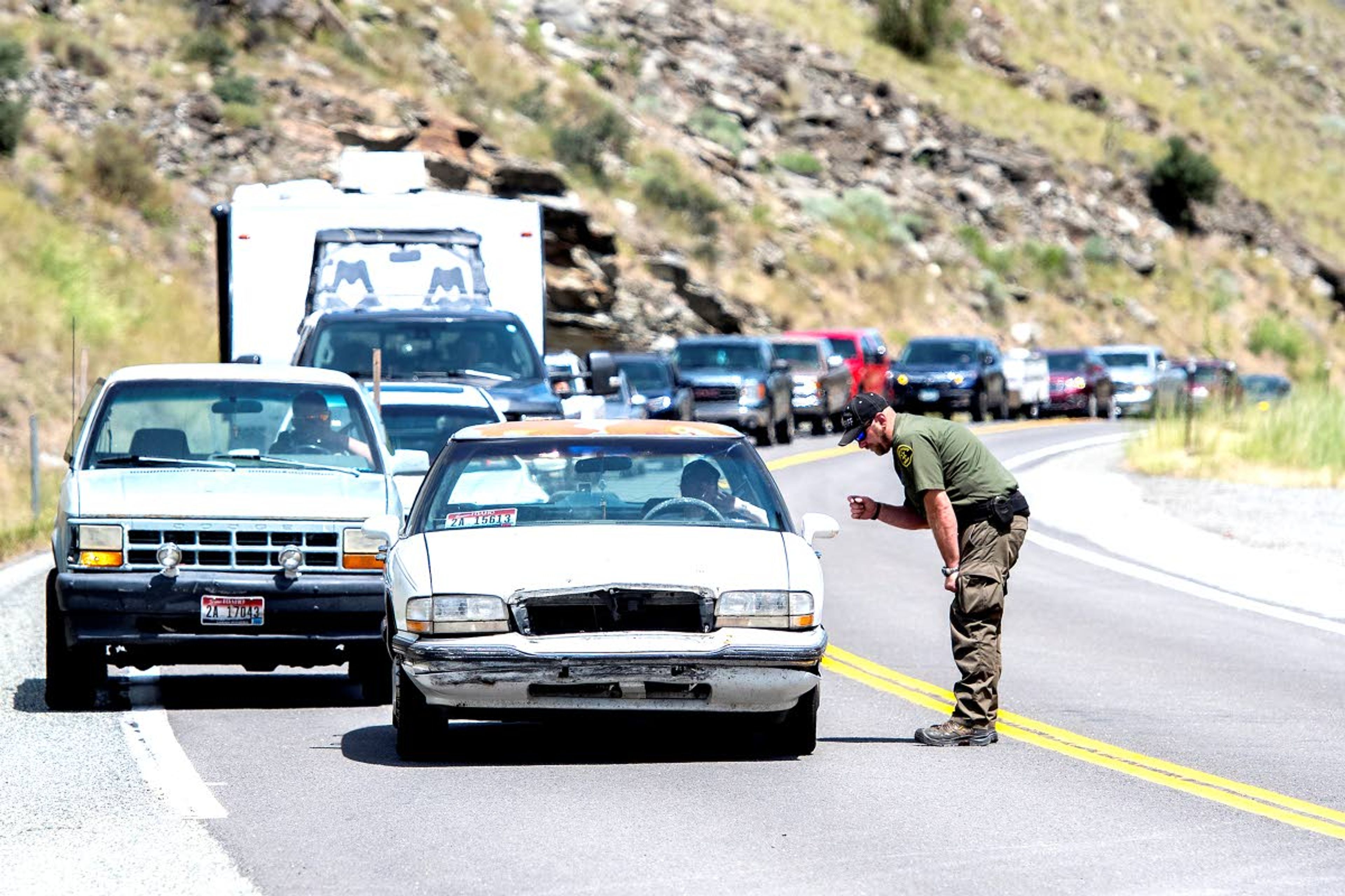 A sheriff asks people where they are going and explains that the road is closed because of a rock slide Friday.