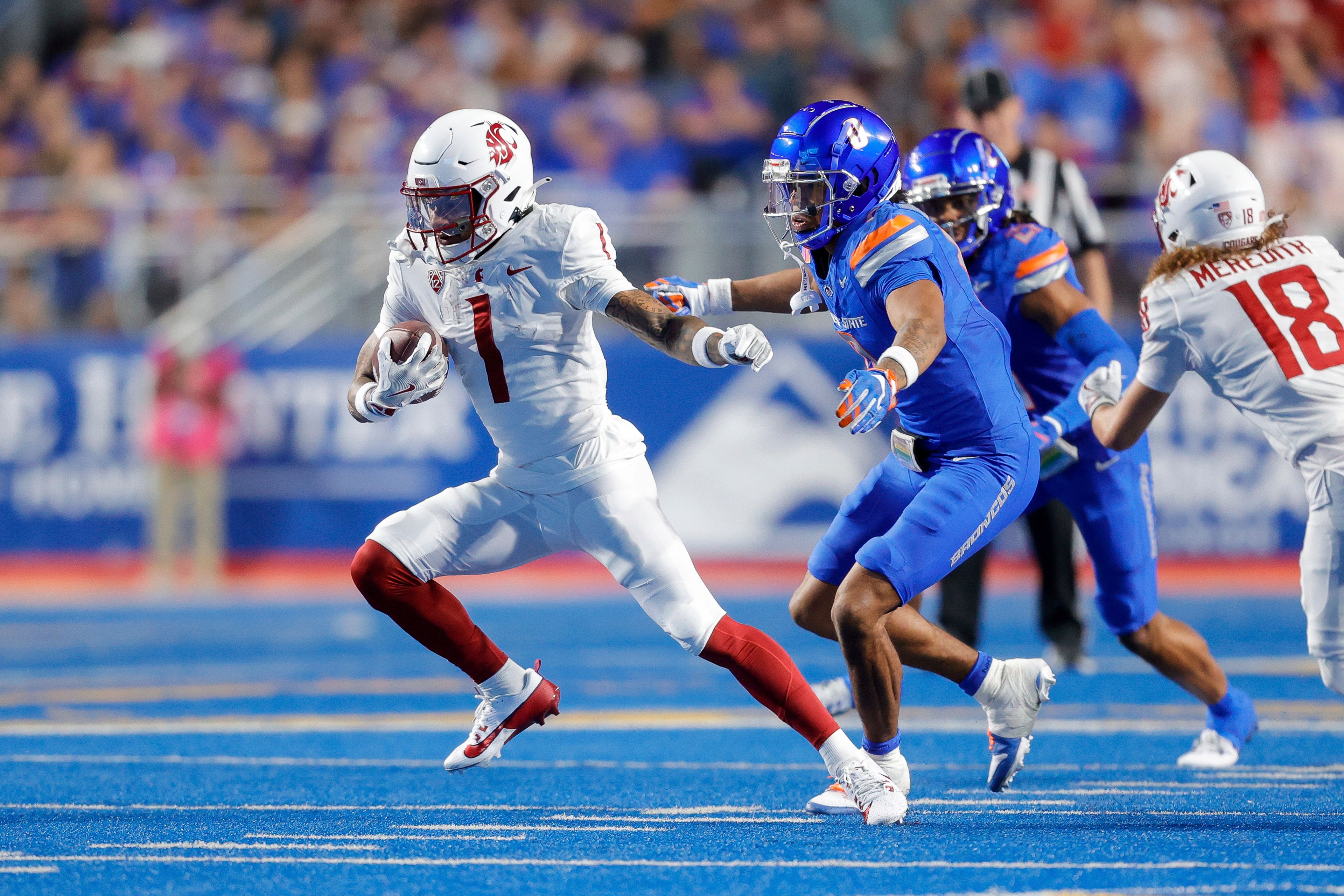 Washington State wide receiver Kris Hutson (1) turns up field in front of Boise State safety Ty Benefield (0) after a catch in the first half of an NCAA college football game, Saturday, Sept. 28, 2024, in Boise, Idaho. (AP Photo/Steve Conner)