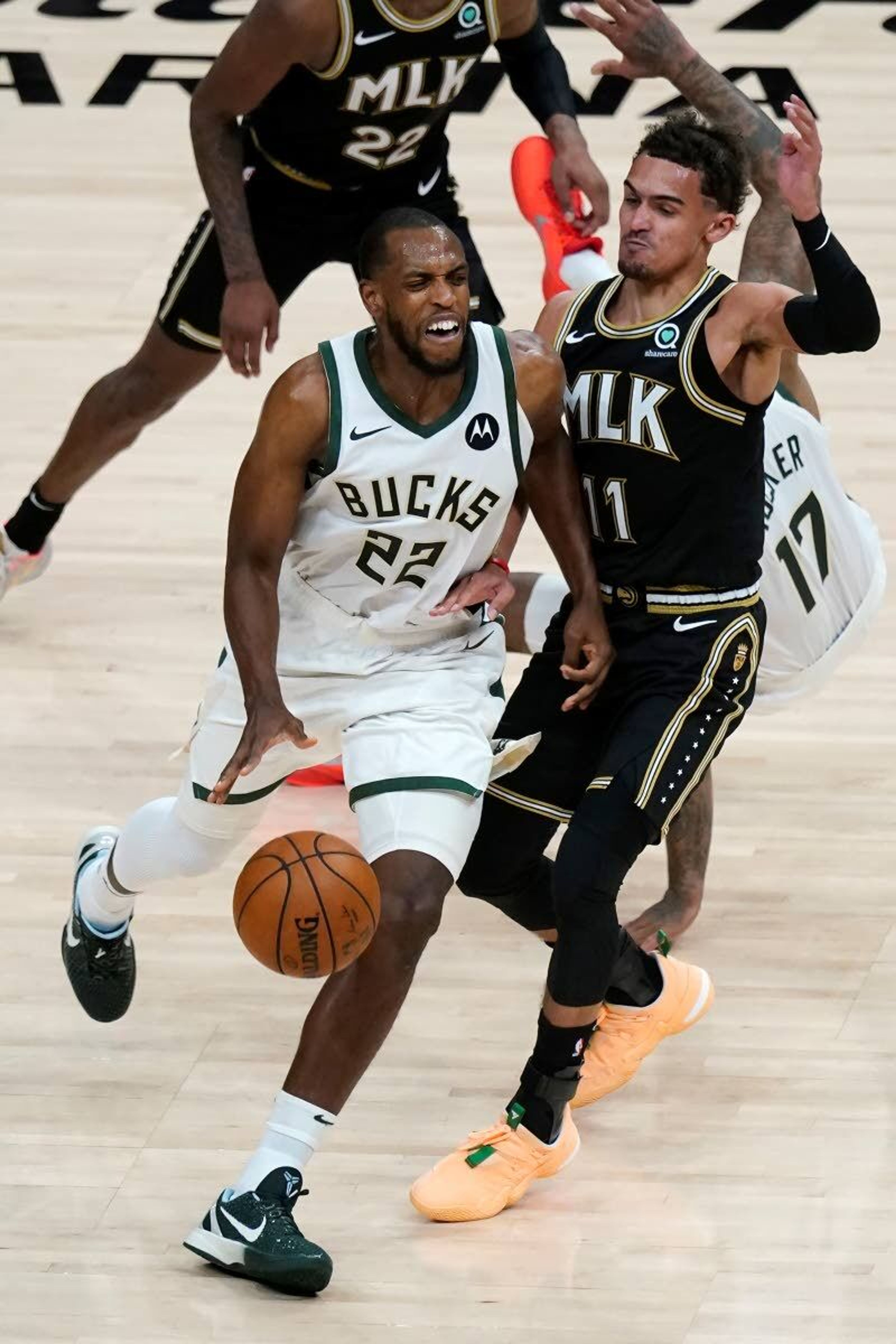 Milwaukee Bucks forward Khris Middleton (22) works past Atlanta Hawks guard Trae Young (11) during the second half in Game 6 of the Eastern Conference finals in the NBA basketball playoffs Saturday, July 3, 2021, in Atlanta. (AP Photo/John Bazemore)