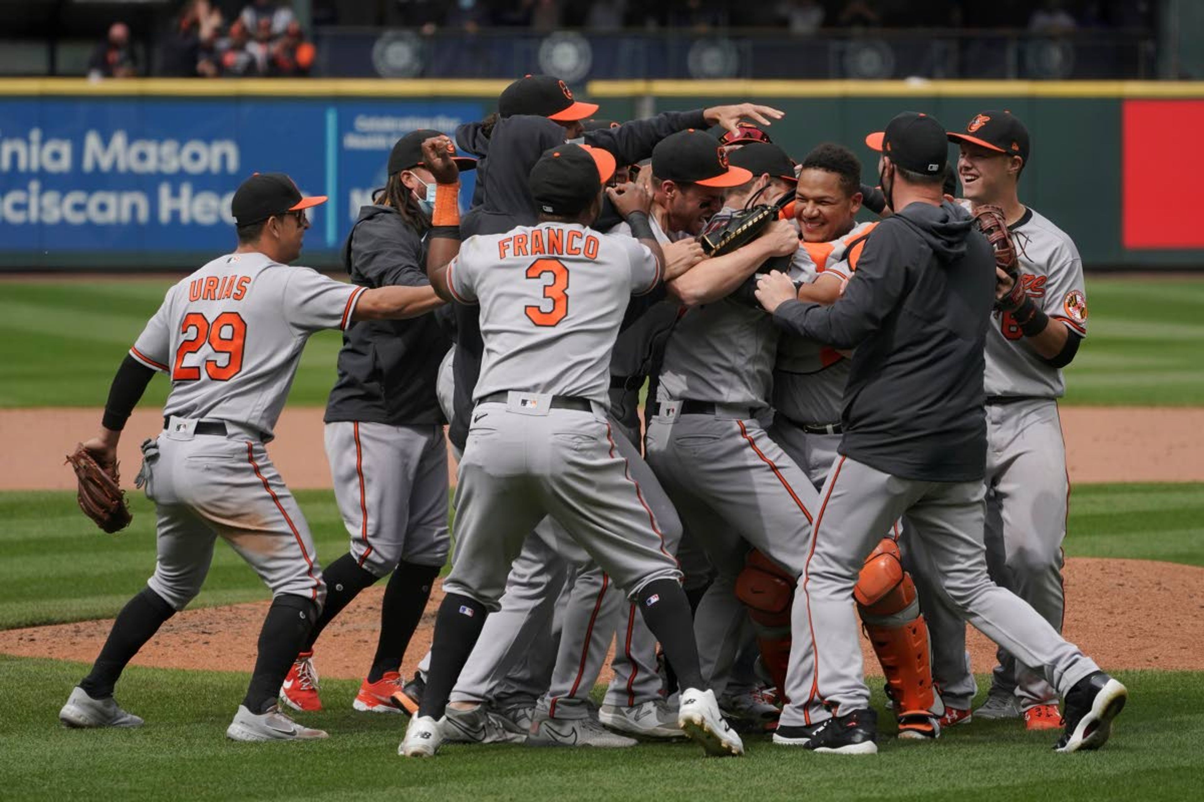 Baltimore Orioles starting pitcher John Means is mobbed by teammates after he threw a no-hitter in the Orioles' baseball game against the Seattle Mariners, Wednesday, May 5, 2021, in Seattle. The Orioles won 6-0. (AP Photo/Ted S. Warren)