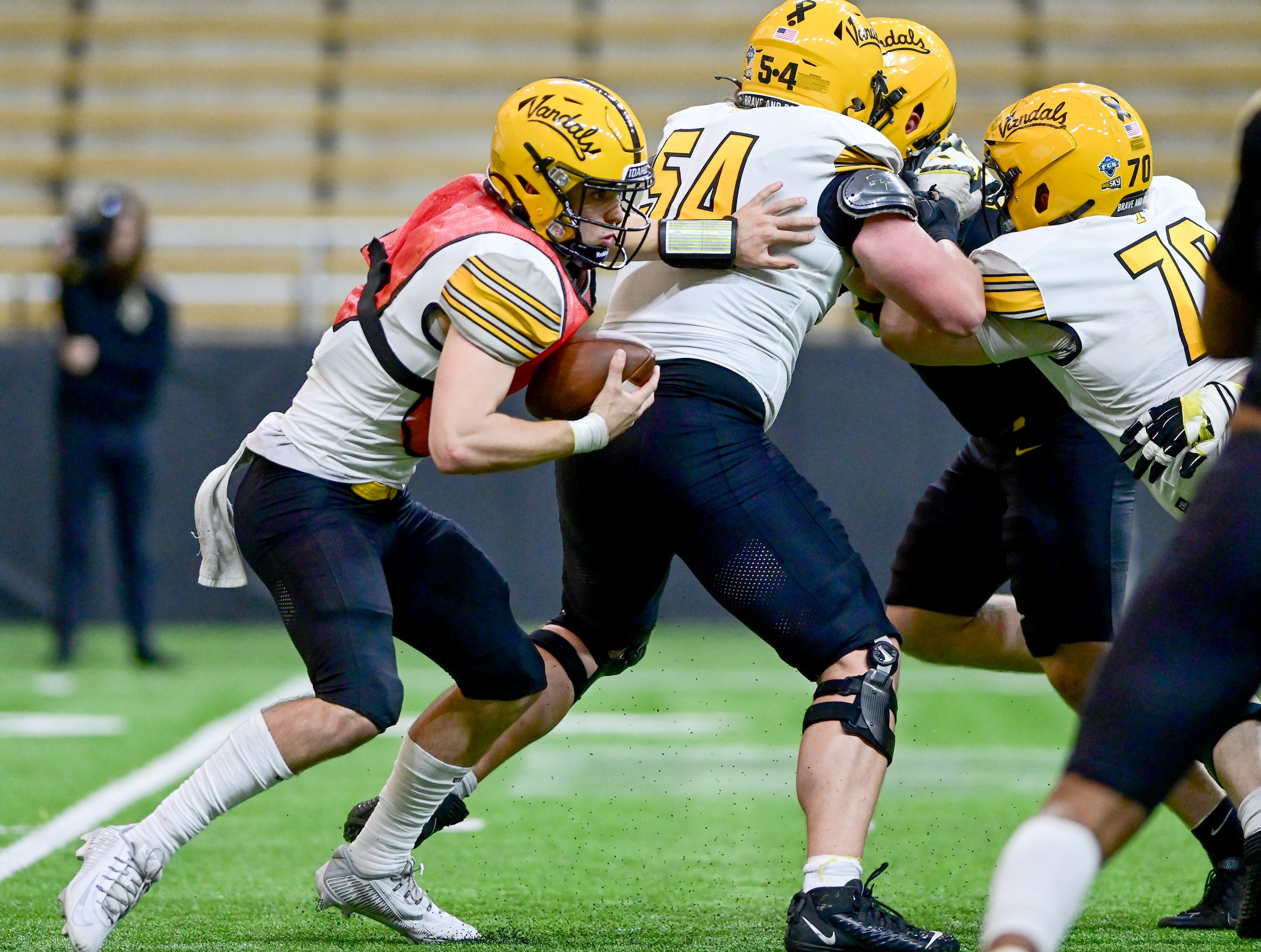 Vandals quarterback Hogan Carmichael, left, carries the ball in a running play at the annual spring game at the P1FCU Kibbie Dome in Moscow on Friday.