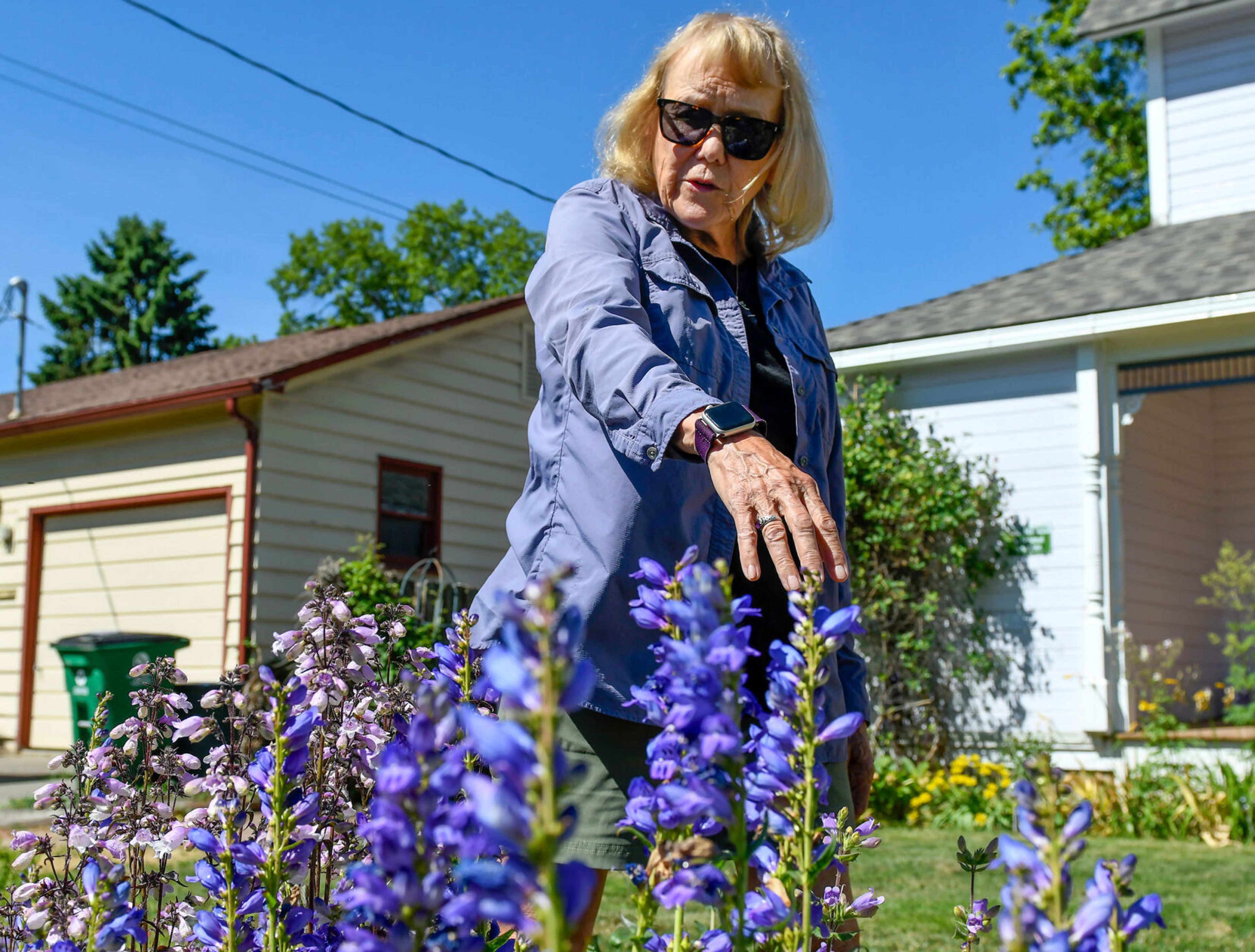 Pam Brunsfeld, a retired University of Idaho botany instructor and Stillinger Herbarium director and, points out different native species that grow in her garden, including Rocky Mountain Penstemon, front, on Friday in Moscow.