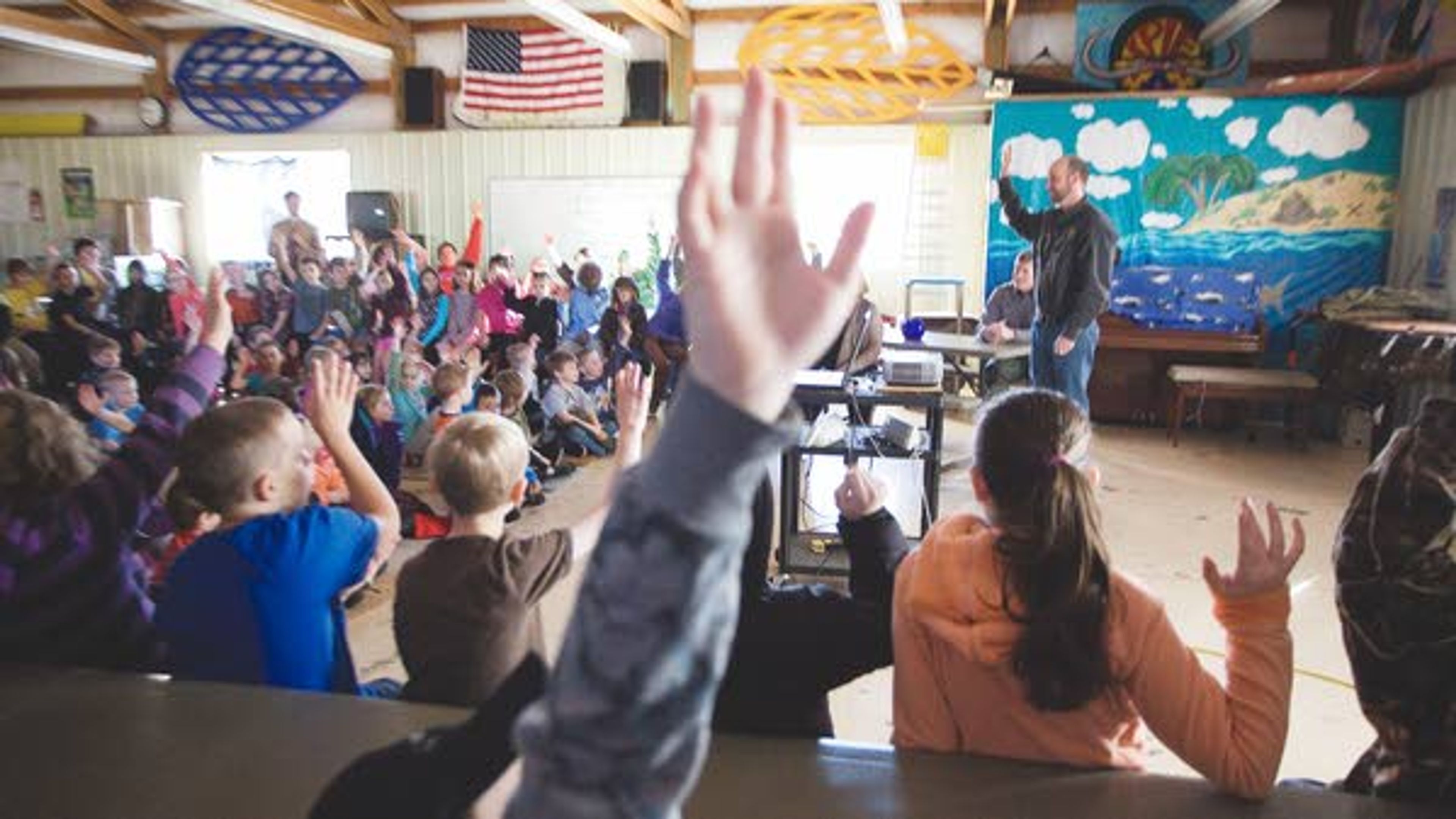 Moscow Charter School students raise their hands to show who has caught a fish in Idaho after Brett Bowersox, standing at right, a fish biologist with Idaho Department of Fish and Game, asked during a presentation as part of a MCS steelhead egg hatching project on Monday. IDFG delivered one hundred eggs to the school Wednesday.