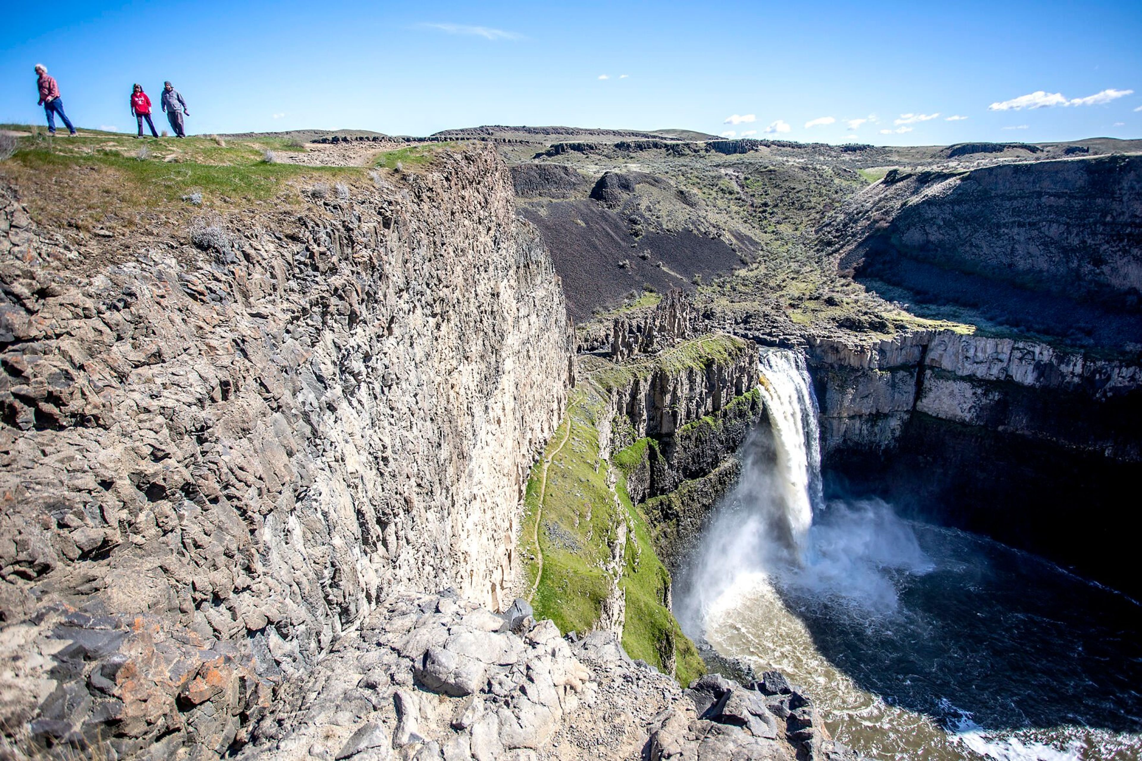 ABOVE: People walk along the trail looking down over Palouse Falls earlier this year. The iconic destination was named Washington’s state waterfall in 2014.LEFT: A photo taken with a drone shows a top-down view of Palouse Falls in early March.