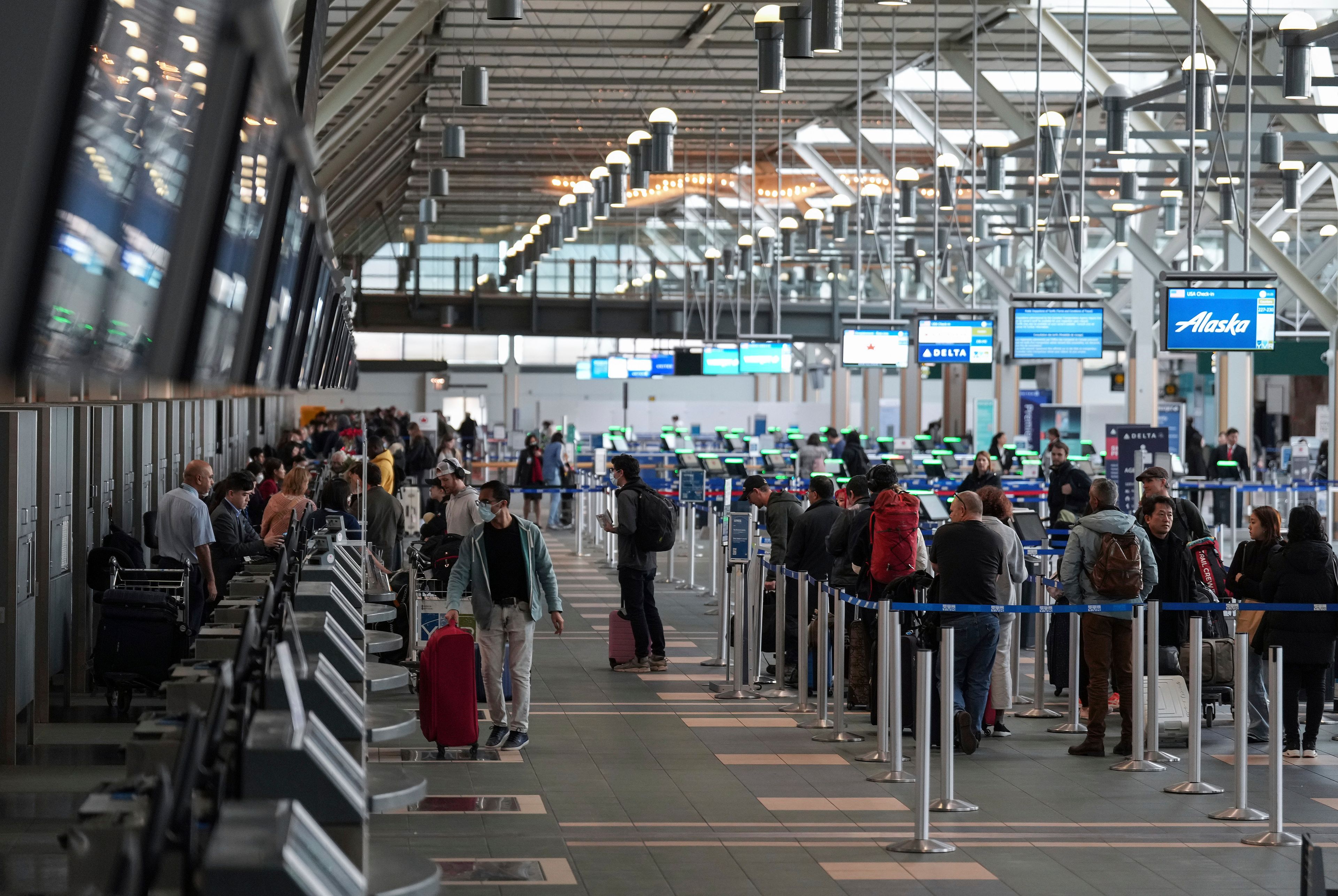 Passengers check in for flights at Vancouver International Airport after operations returned to normal after last week's snowstorm in Richmond, British Columbia, Monday, Dec. 26, 2022. (Darryl Dyck/The Canadian Press via AP)