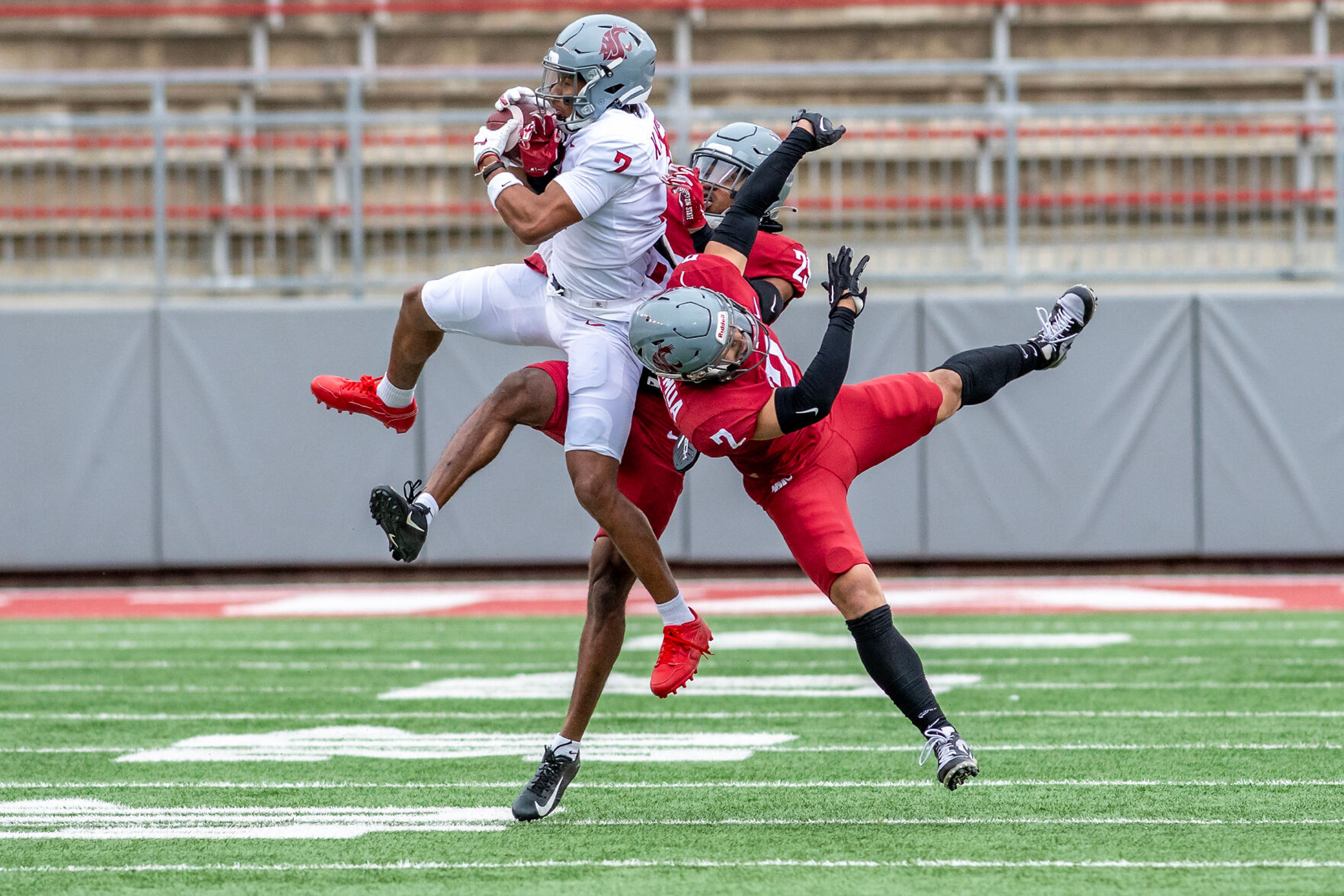 Gray wide receiver Kyle Williams pulls down a catch under pressure from Crimson defensive back Jackson Lataimua (2) and defensive back Jamorri Colson in a quarter of the Crimson and Gray Game at Washington State University in Pullman.