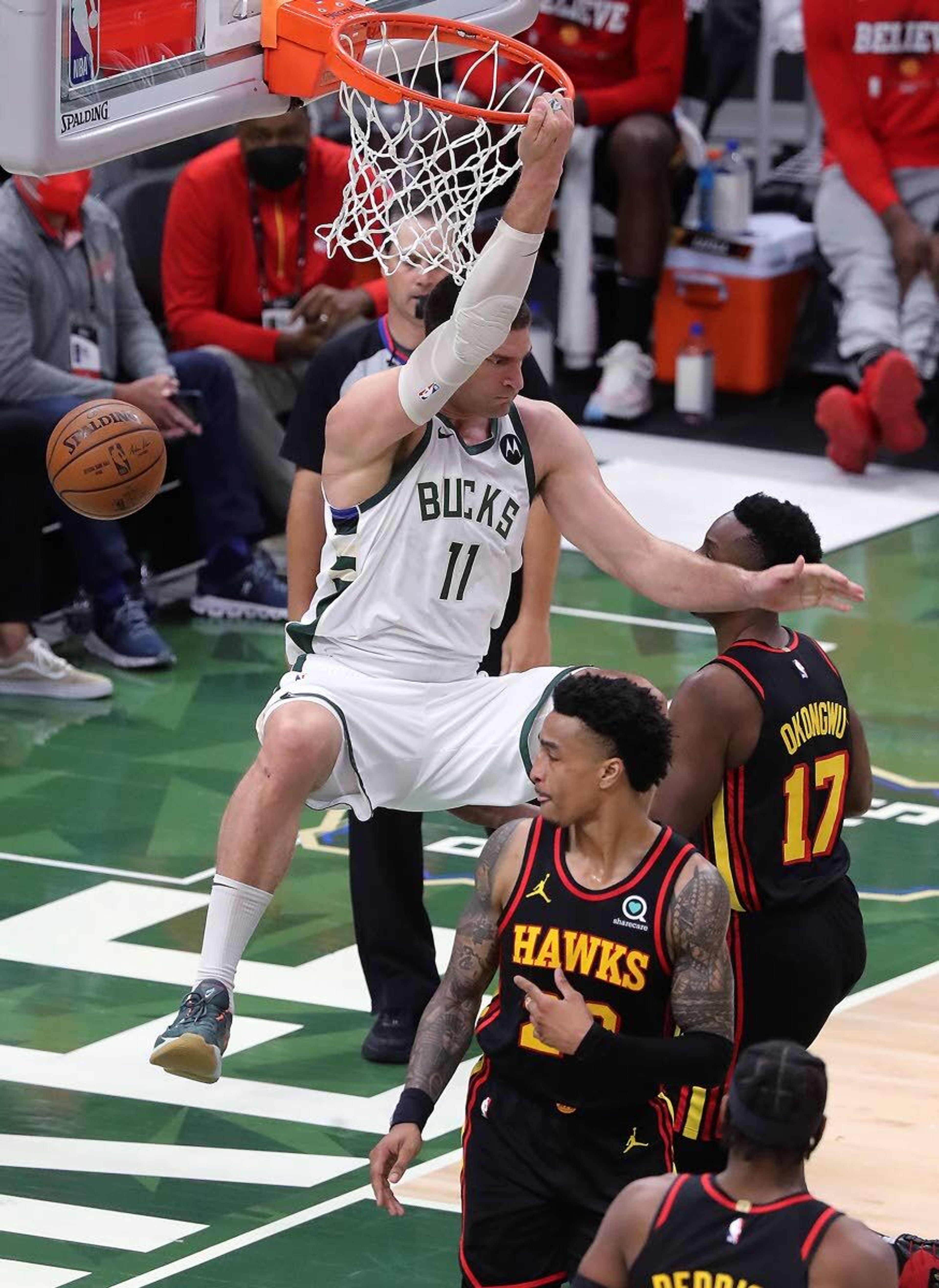 Atlanta Journal-ConstitutionMilwaukee center Brook Lopez hangs on the basket after dunking on Atlanta’s John Collins during the third quarter of Thursday’s Game 5 of the Eastern Conference final series.