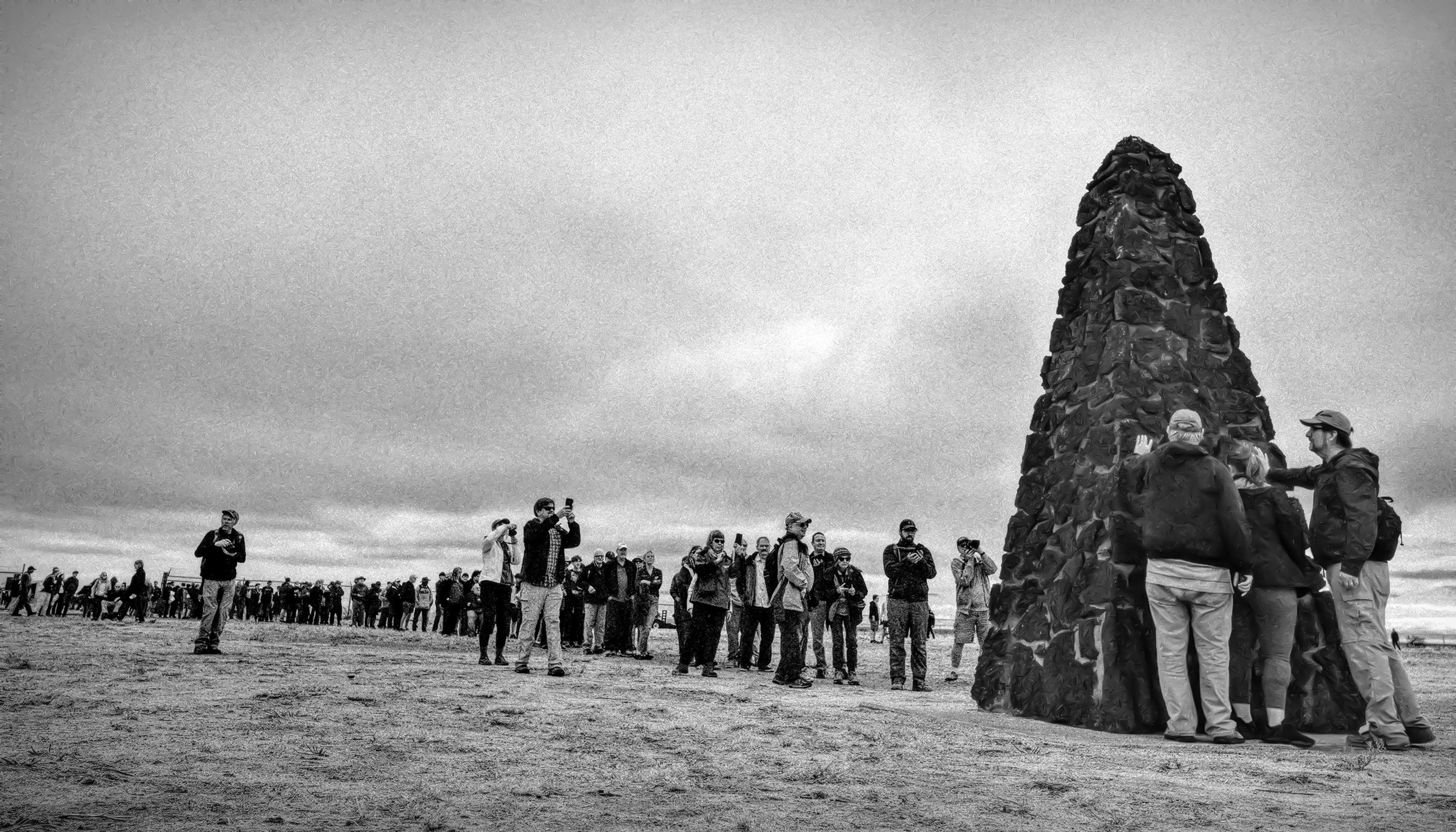 Visitors to the Trinity site line up to take selfies in front of the ground zero monument, or to lay hands on it.,