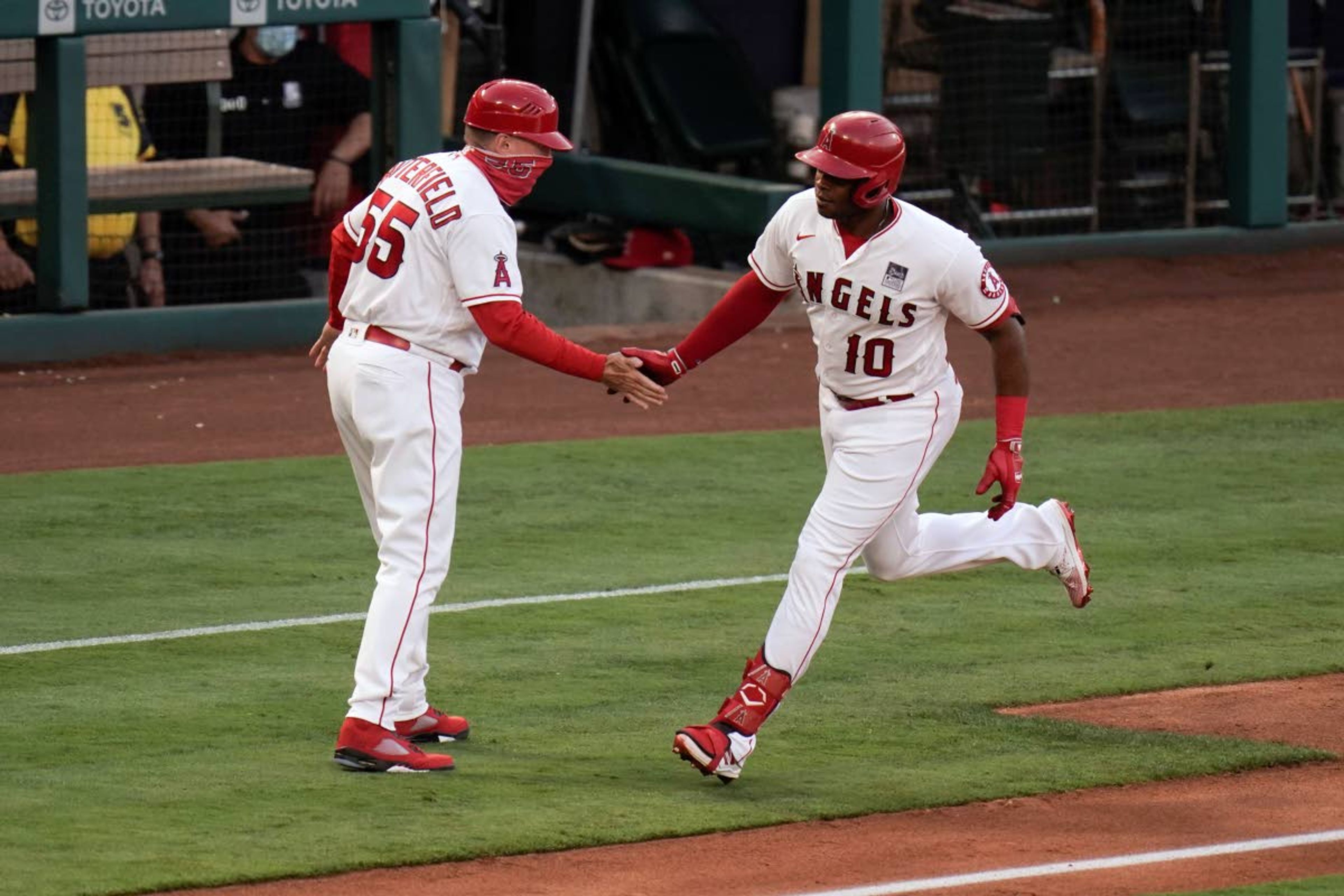 Los Angeles Angels' Justin Upton, right, celebrates his home run with third base coach Brian Butterfield during the second inning of the team's baseball game against the Seattle Mariners in Anaheim, Calif., Thursday, June 3, 2021. (AP Photo/Jae C. Hong)