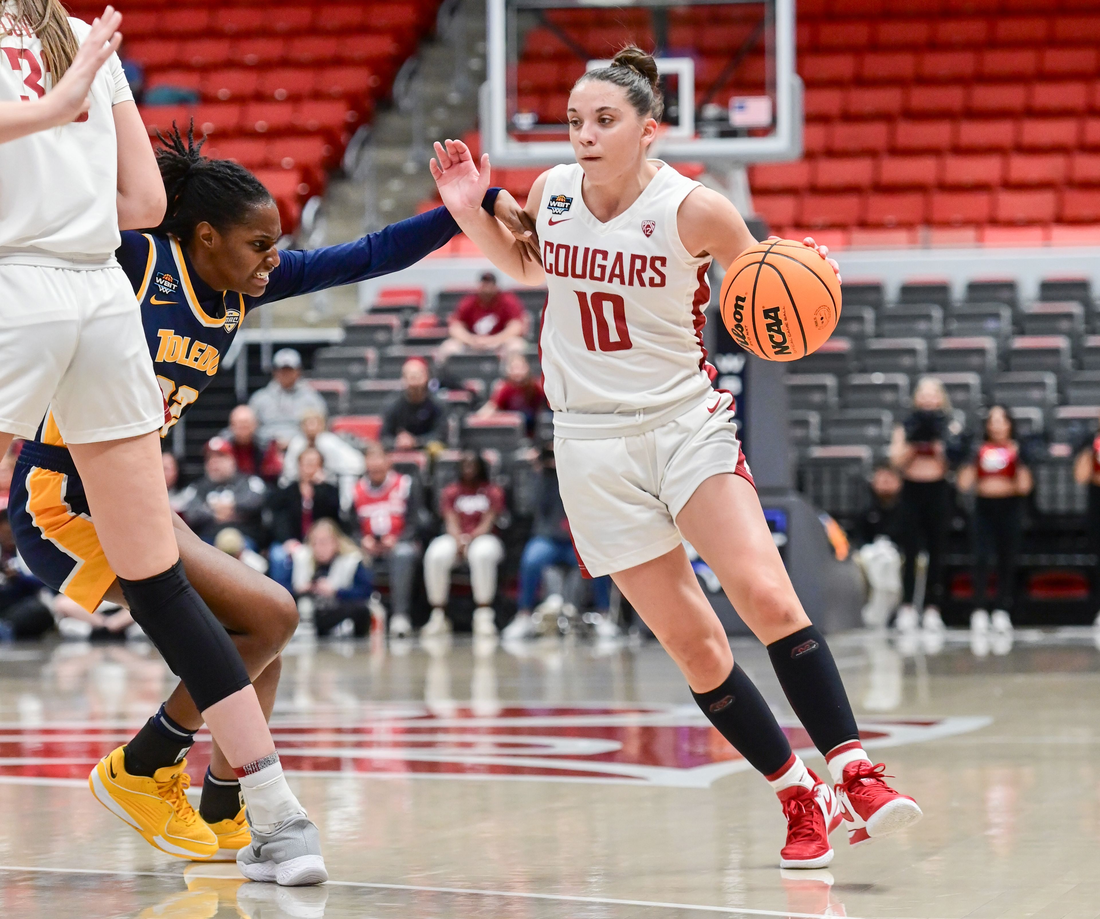 Toledo Rockets guard Khera Goss (22) reaches for Washington State Cougars guard Eleonora Villa (10) while moving down the court in Pullman on March 28, 2024.,