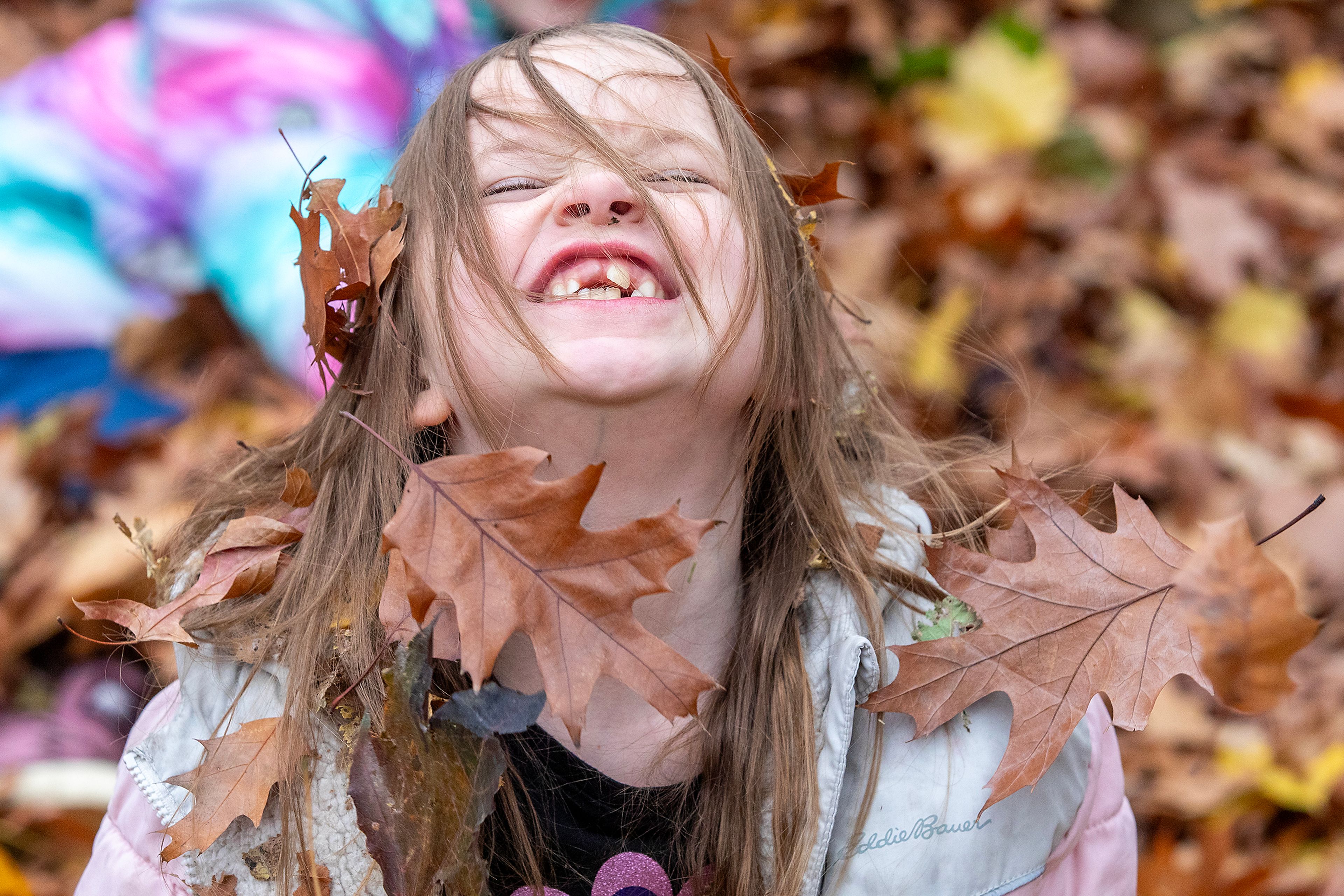 Paxley Jensen has leaves fall down from her hair Wednesday outside Children's House Montessori School at Pioneer Park Wednesday in Lewiston.