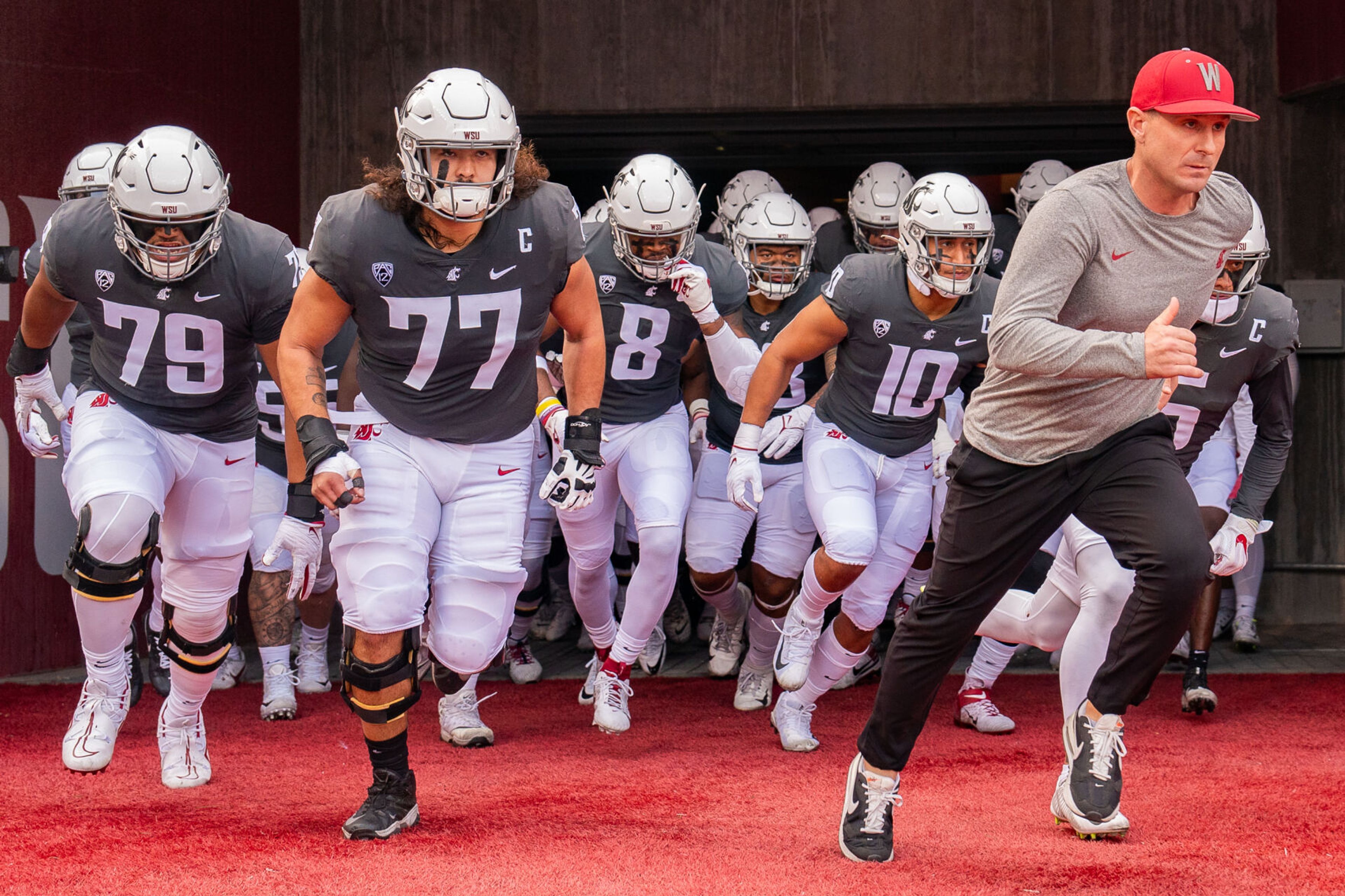 Washington State coach Jake Dickert, right, leads his team to the field before a game against Oregon State on Sept. 23 at Gesa Field in Pullman.