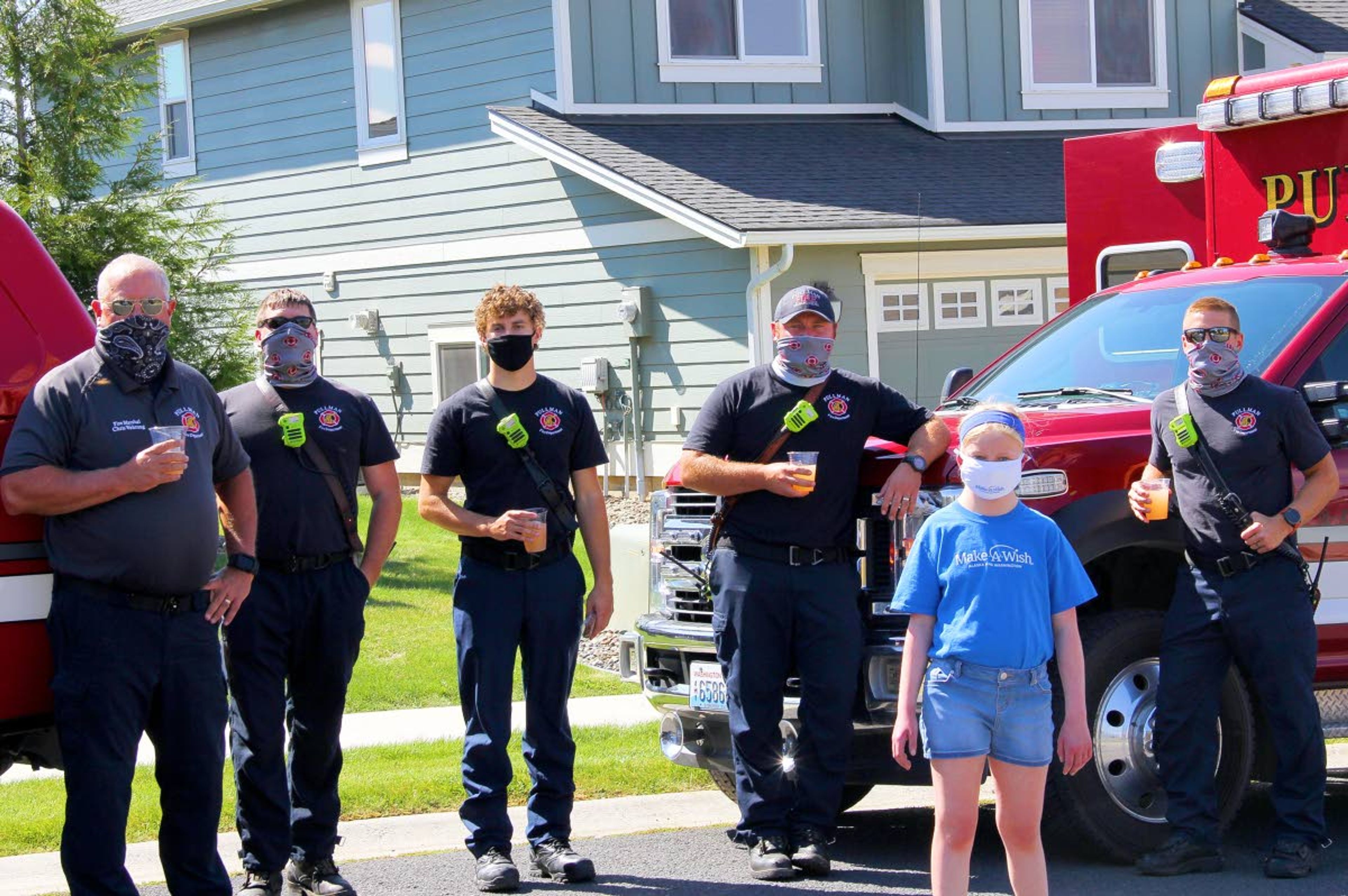 Shay Connell stands with a crew of Pullman firefighters during the third annual Make-A-Wish Lemonade Stand fundraiser Thursday in Pullman. The fundraiser, organized by Connell and friends Marissa and Jack Carper, raised more than $12,000 for the foundation despite the ongoing coronavirus pandemic. The event raised $4,000 in 2018 and $7,000 last year. “The community was beyond amazing and came in droves for lemonade and baked goods, all of which were made by members of the community,” said Kimberly Carper, the mother of Marissa and Jack. “The fire department brought five vehicles with their team members, police officers came up, and PACT EMS from Moscow came as part of their Lights on Lemonade program.”