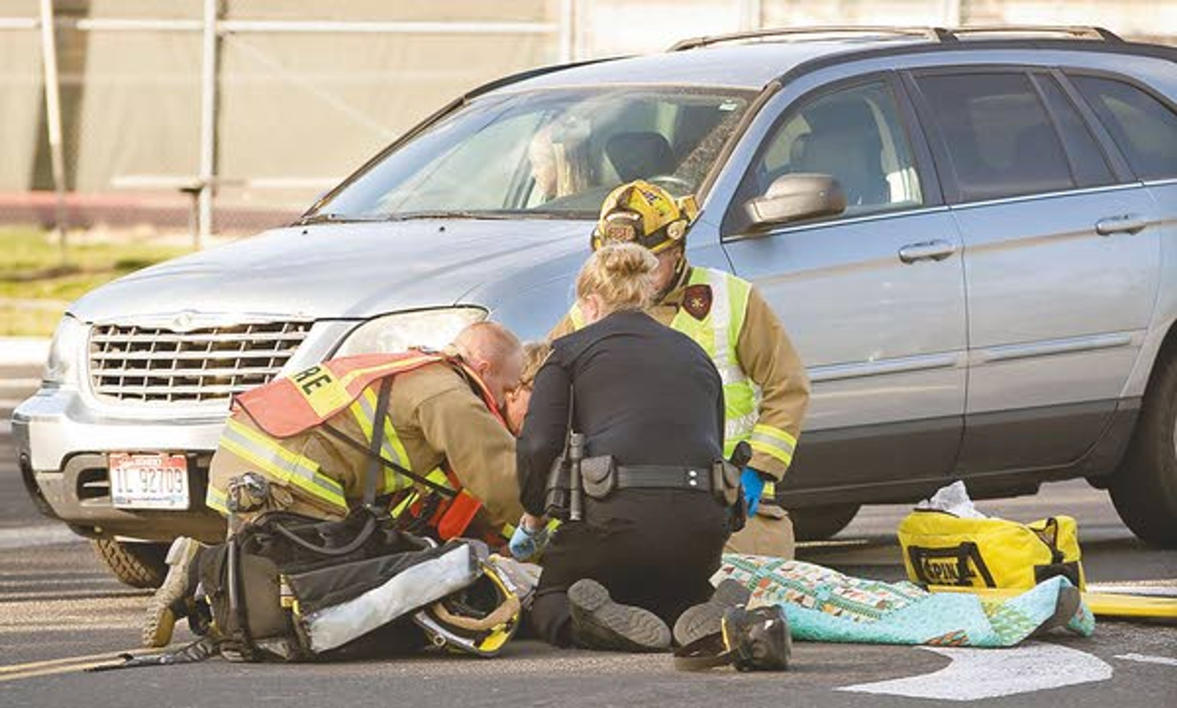 Emergency Medical Technicians and a police officer aid a Moscow Middle School student after she was hit by a car at the intersection of Mountain View Road and D Street in Moscow on Monday.