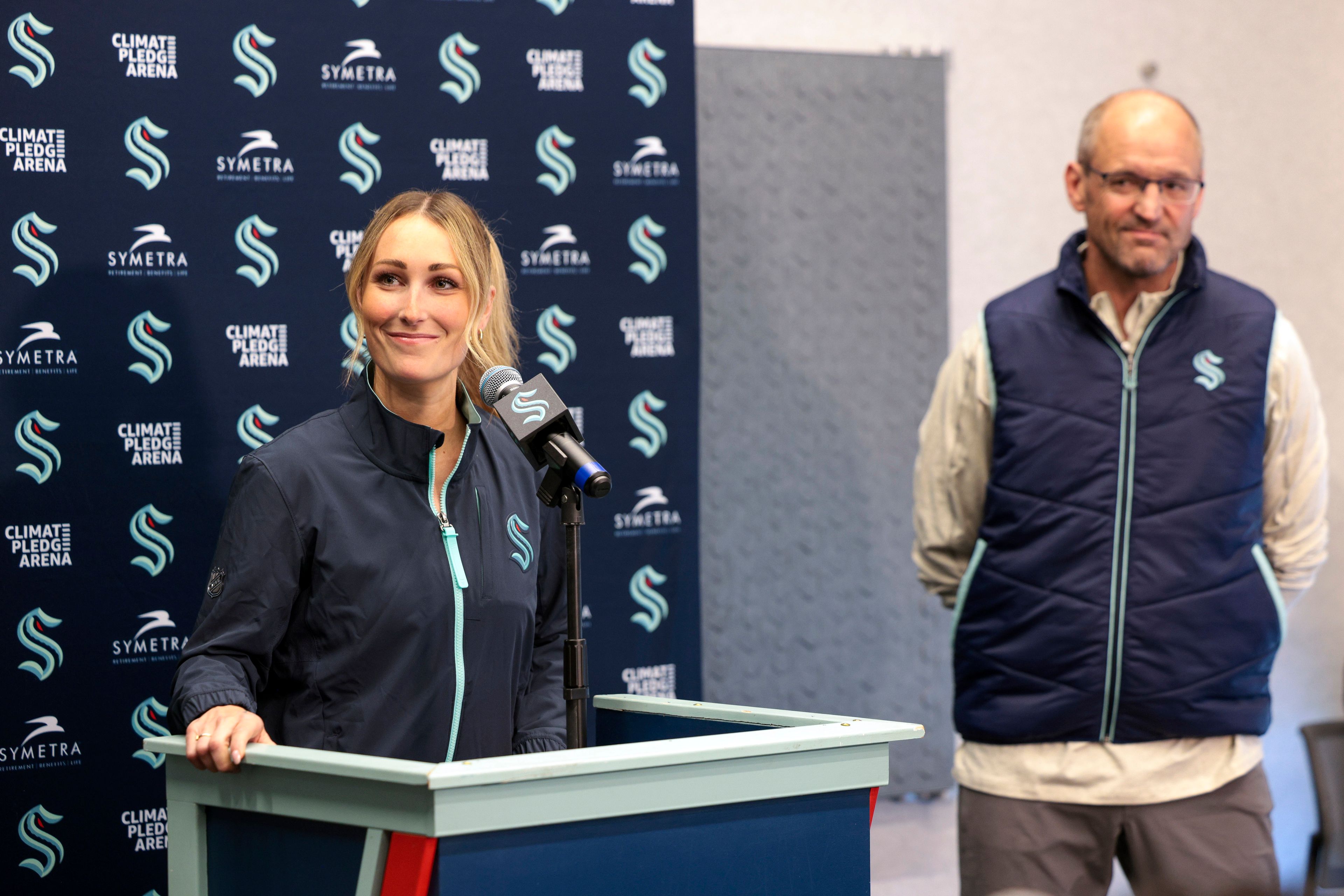 Seattle Kraken new assistant coach Jessica Campbell, left, speaks, as Kraken head coach Dan Bylsma listens during an NHL hockey press conference Wednesday, July 3, 2024, in Seattle. Campbell will become the first woman to work on the bench of an NHL franchise after the team hired her as an assistant coach Wednesday .(AP Photo/Jason Redmond)