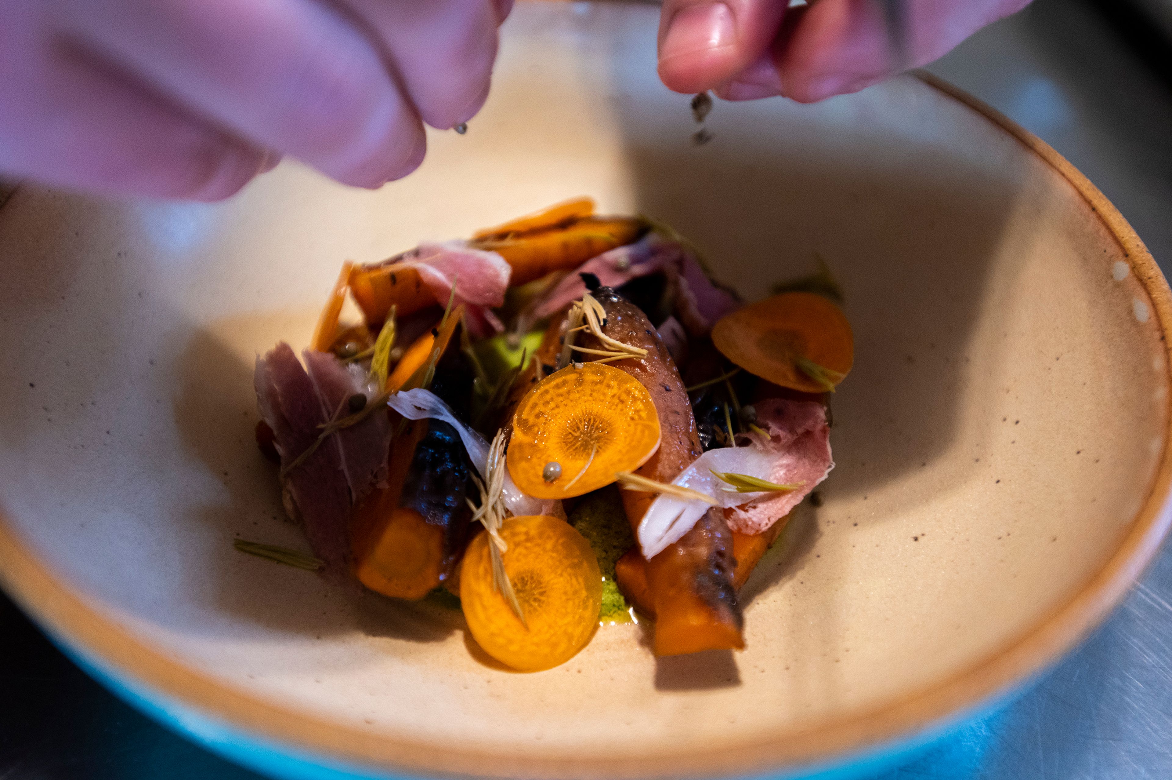 Pecoraro sprinkles pickled green coriander over the dish.