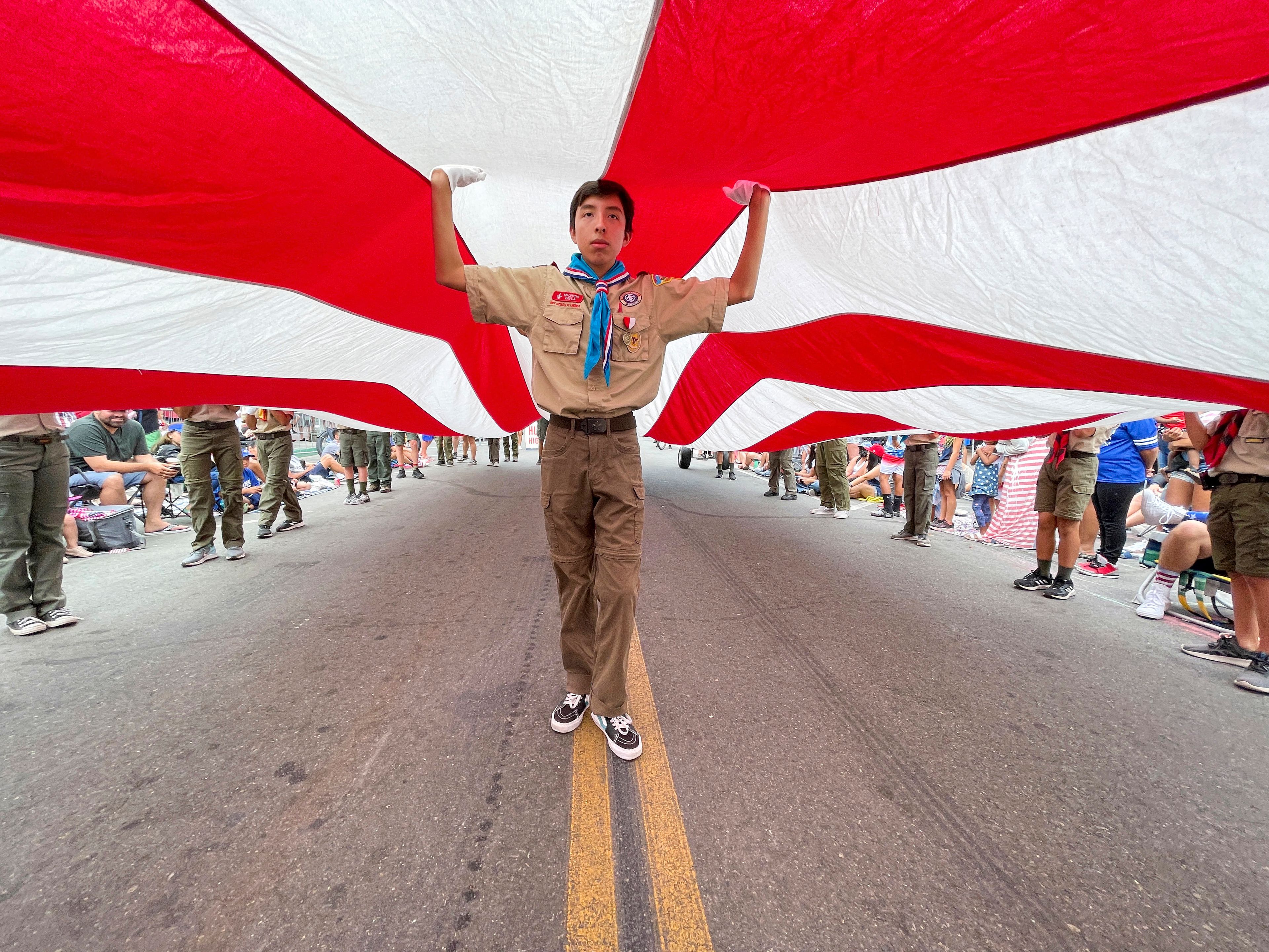 Boy Scouts carry Huntington Beach's Historic Freedom Flag up Main Street during The 118th Huntington Beach 4th of July Parade in Huntington Beach, Calif., on Monday, July 4, 2022. (Jeff Gritchen/The Orange County Register via AP)