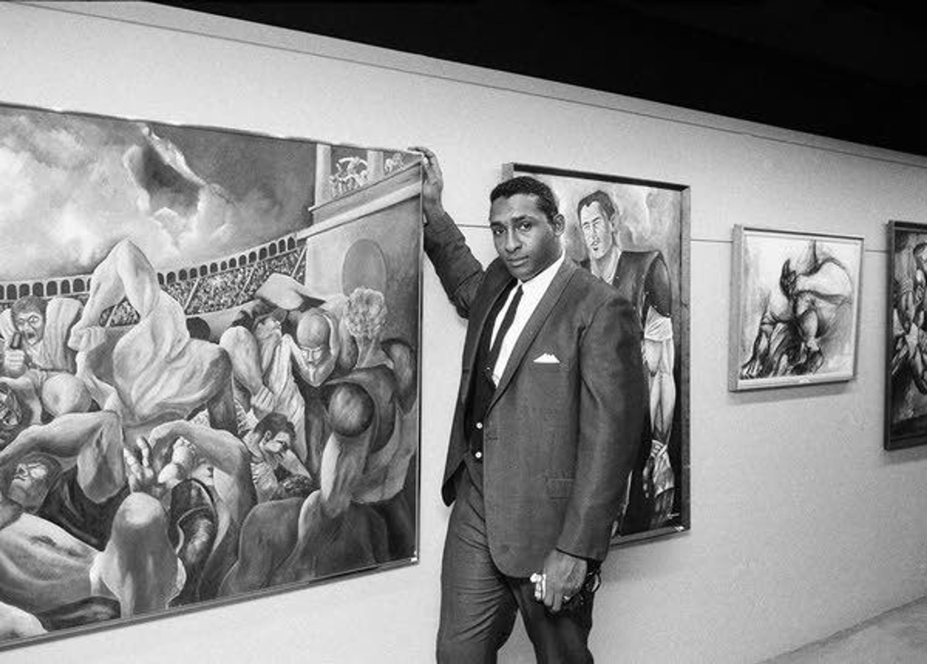 Ernie Barnes, former offensive lineman for both the American and National Football leagues, stands alongside one of his paintings Nov. 15, 1966, at the Grand Central Art Gallery in New York.