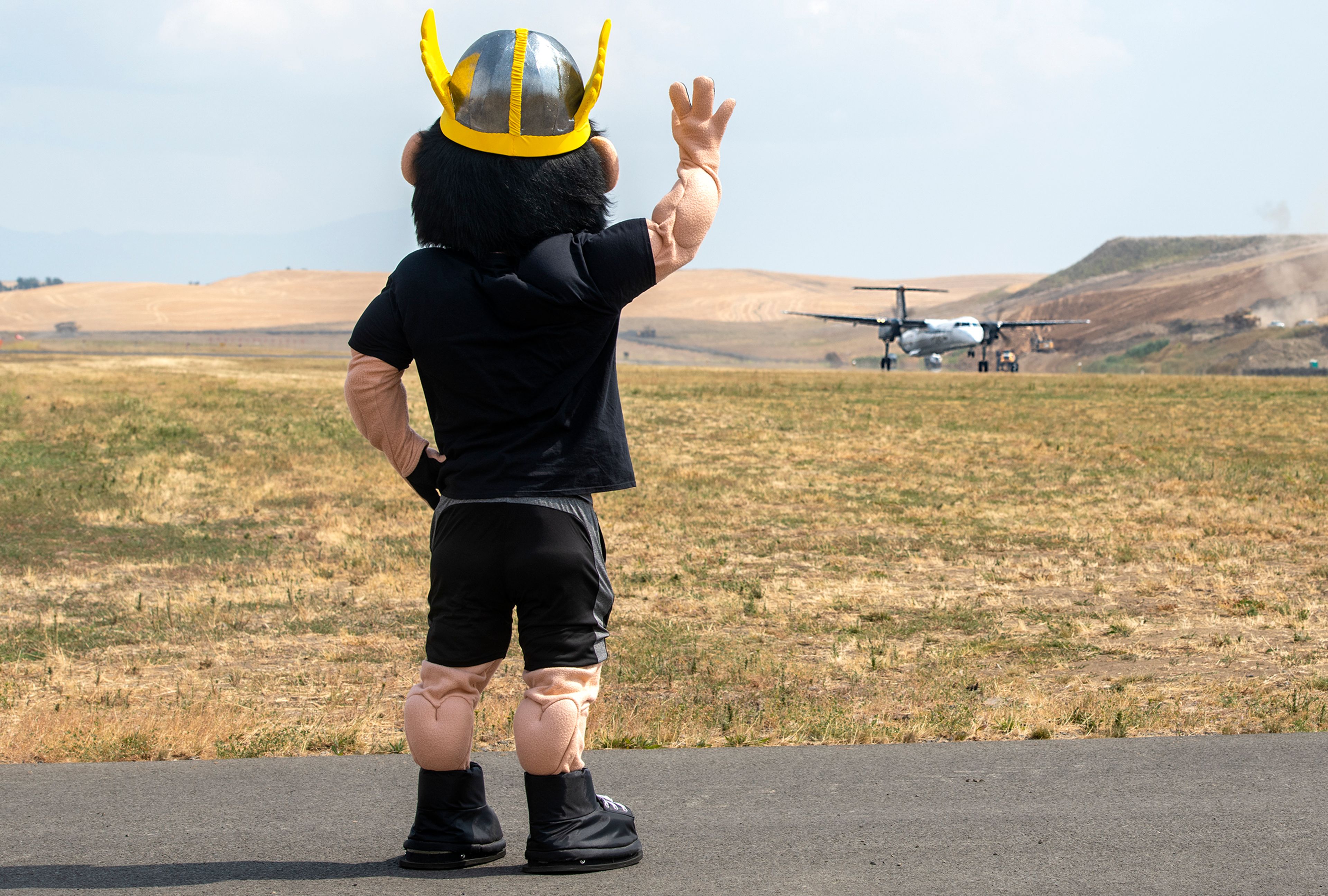 Zach Wilkinson/Daily NewsUniversity of Idaho mascot Joe Vandal waves goodbye to Flight 2496, which was the inaugural flight from Pullman to Boise, on the runway at the Pullman-Moscow Regional Airport last August. 