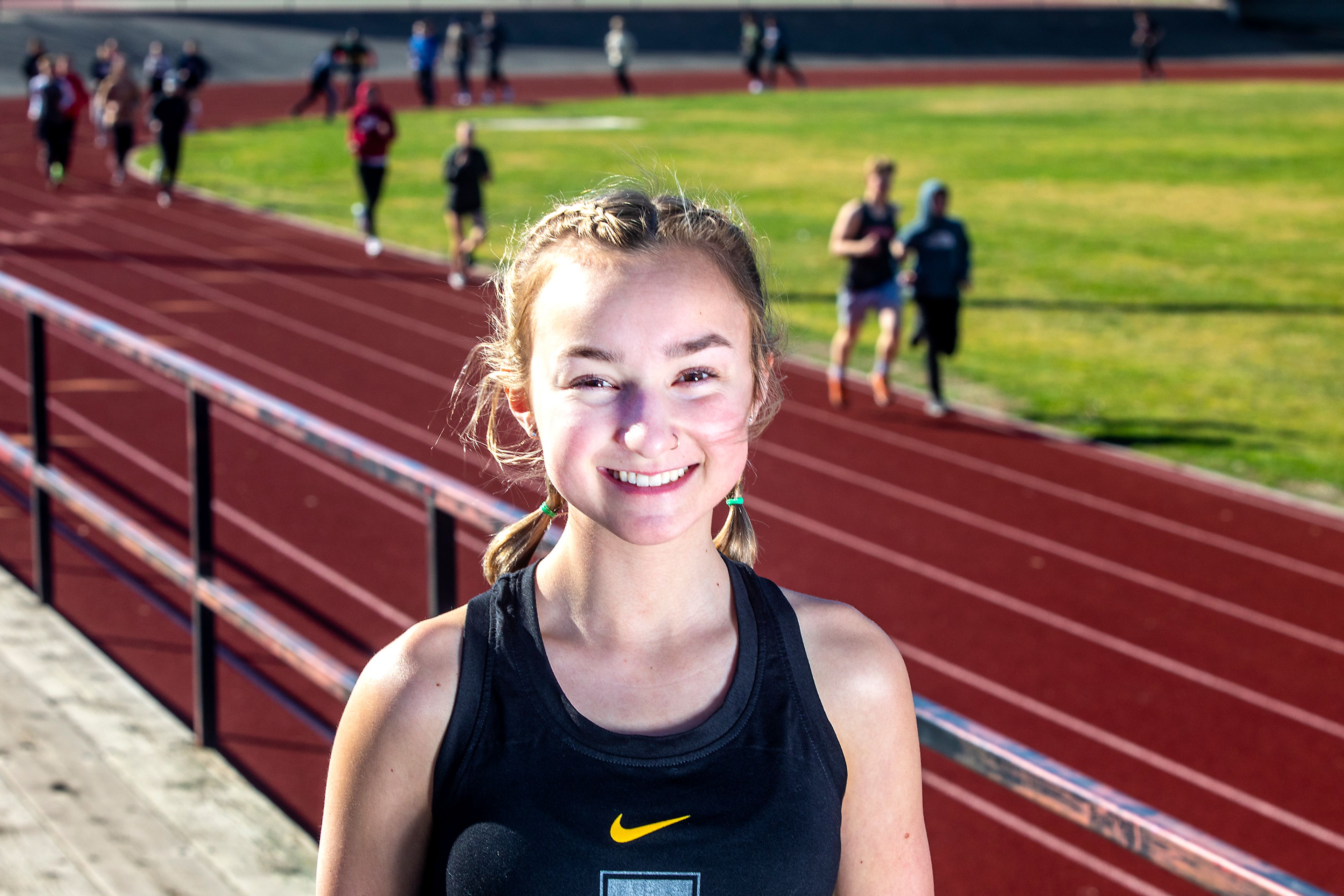 Asotin’s Chloe Overberg poses for a photo as runners move down the track during a meet at Clarkston High School earlier this season.