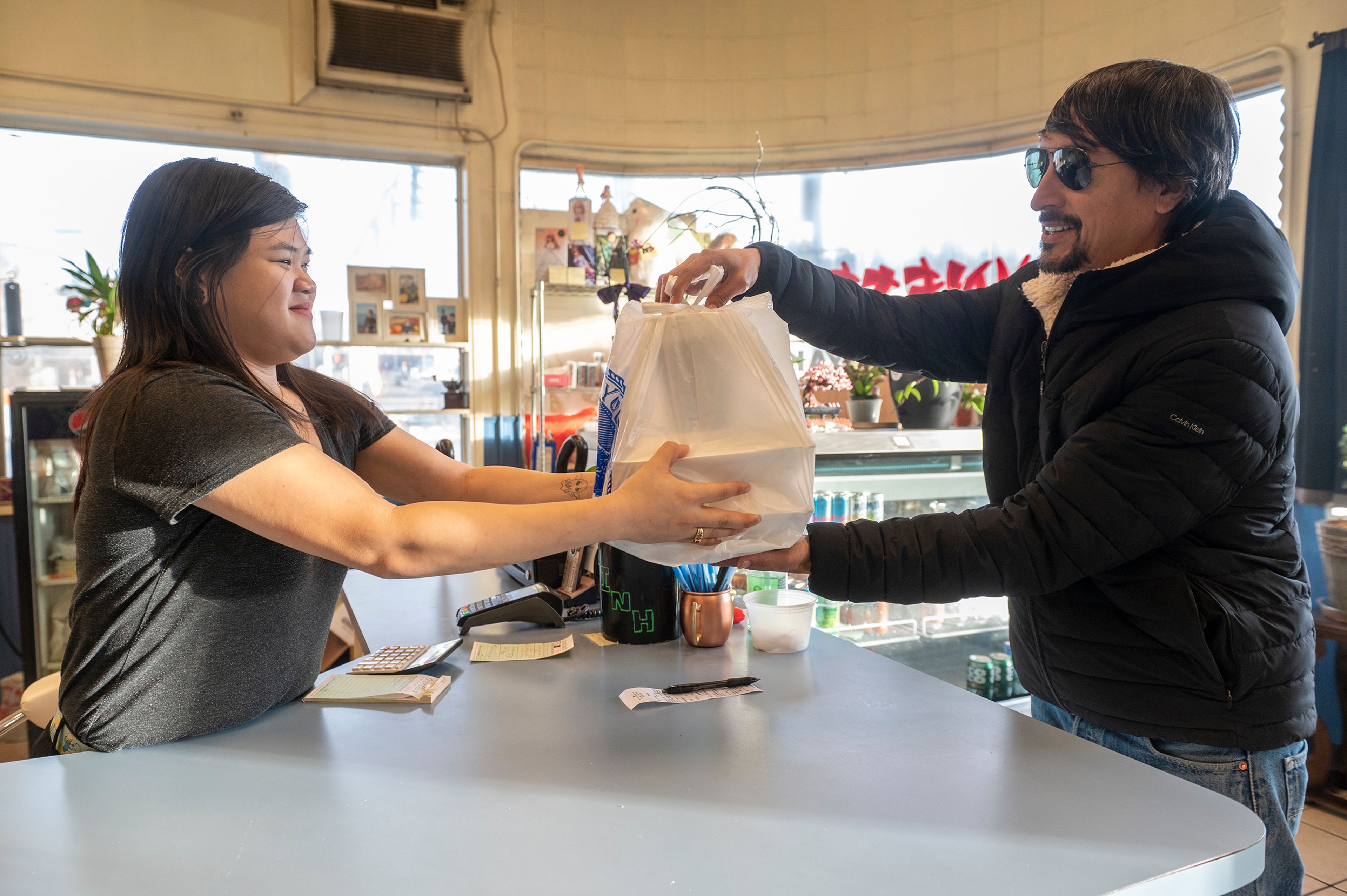 Frank Contreras picks up a delivery order from Minh's Restaurant and Cafe in Pullman. Contreras is seeking asylum in the U.S. and is not undocumented.