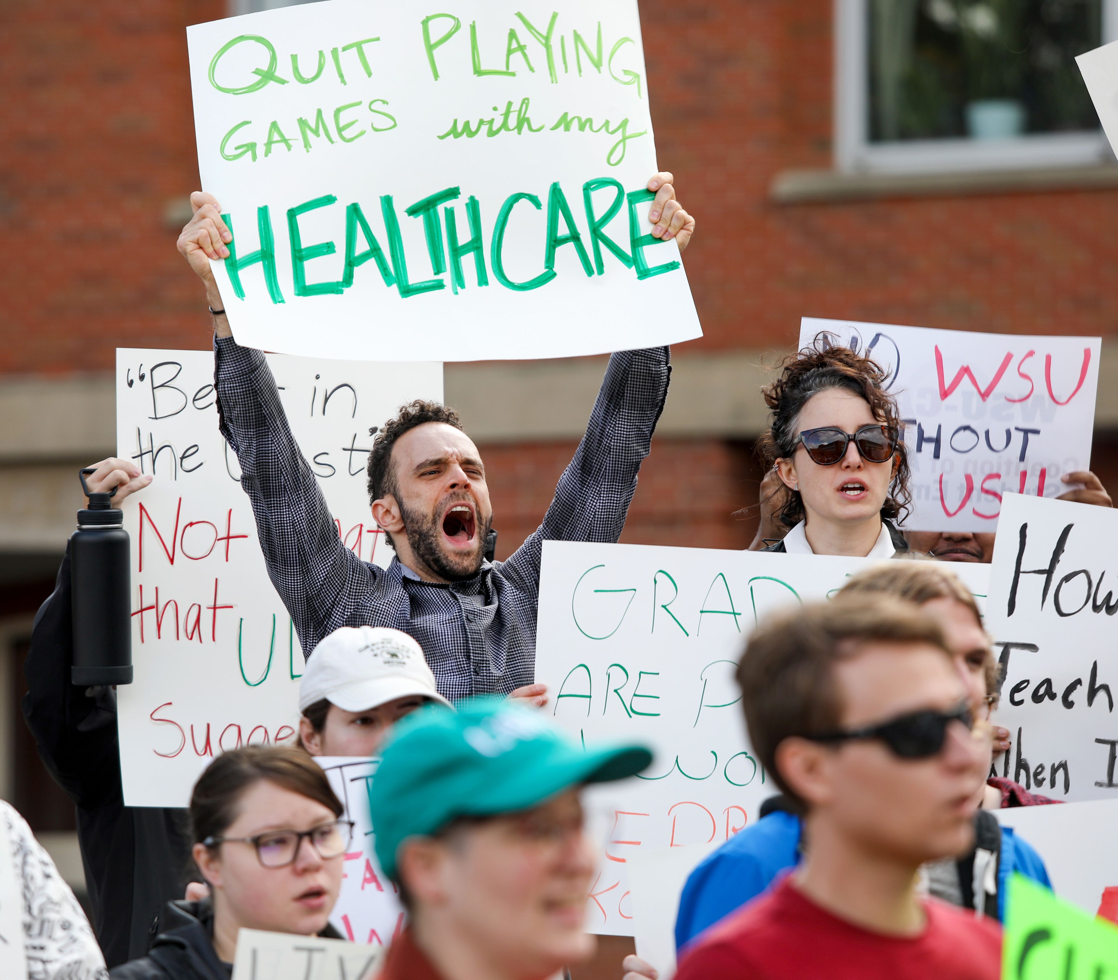 Steven Cassidy, left, a fifth-year PhD student in the college of arts and sciences at Washington State University, cheers in response to speakers at a rally supporting contract negotiations for Academic Student Employees at Glenn Terrell Mall on Wednesday in Pullman.