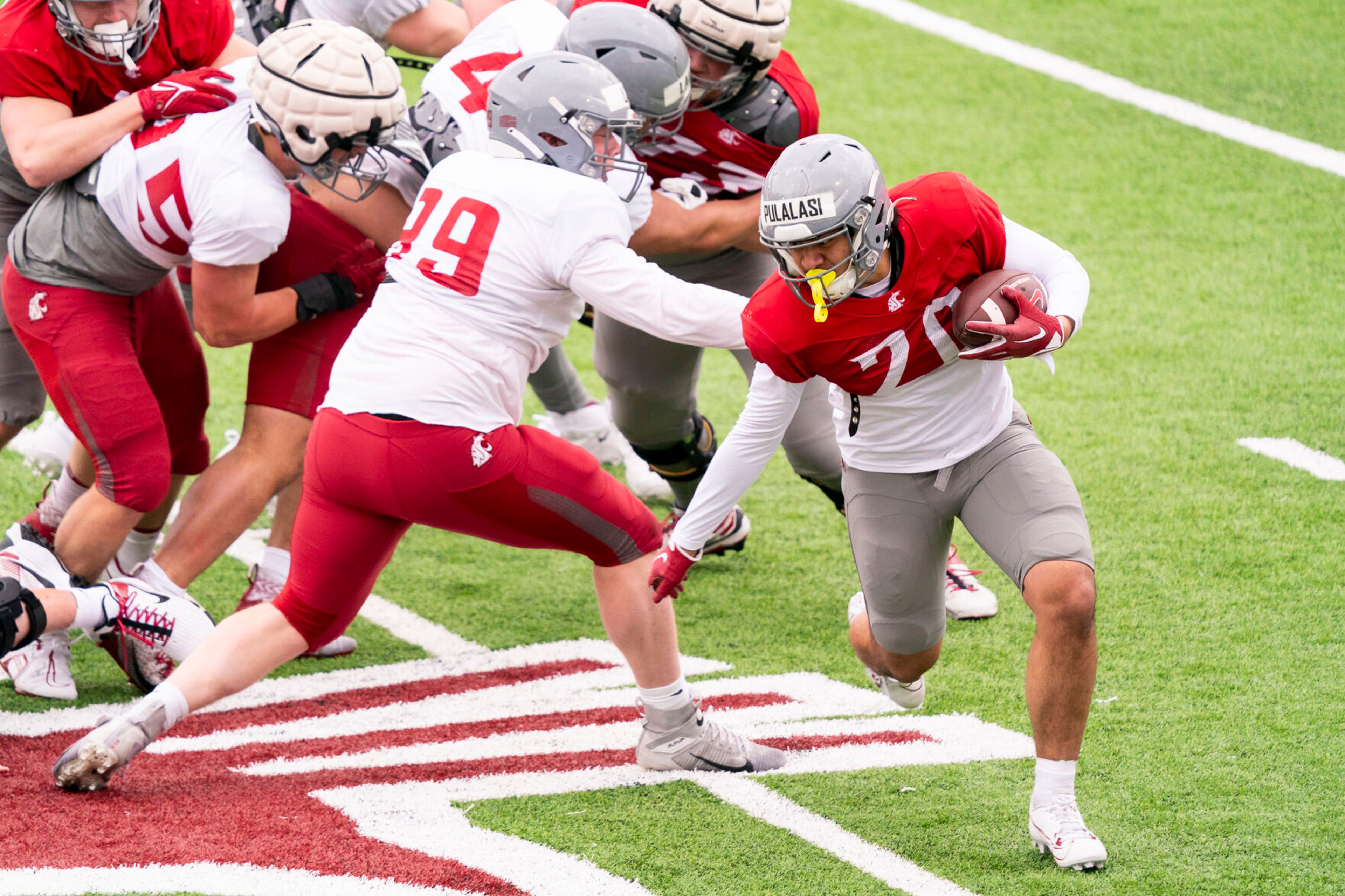 Washington State running back Leo Pulalasi, right, runs with the ball during practice Tuesday at Gesa Field in Pullman.