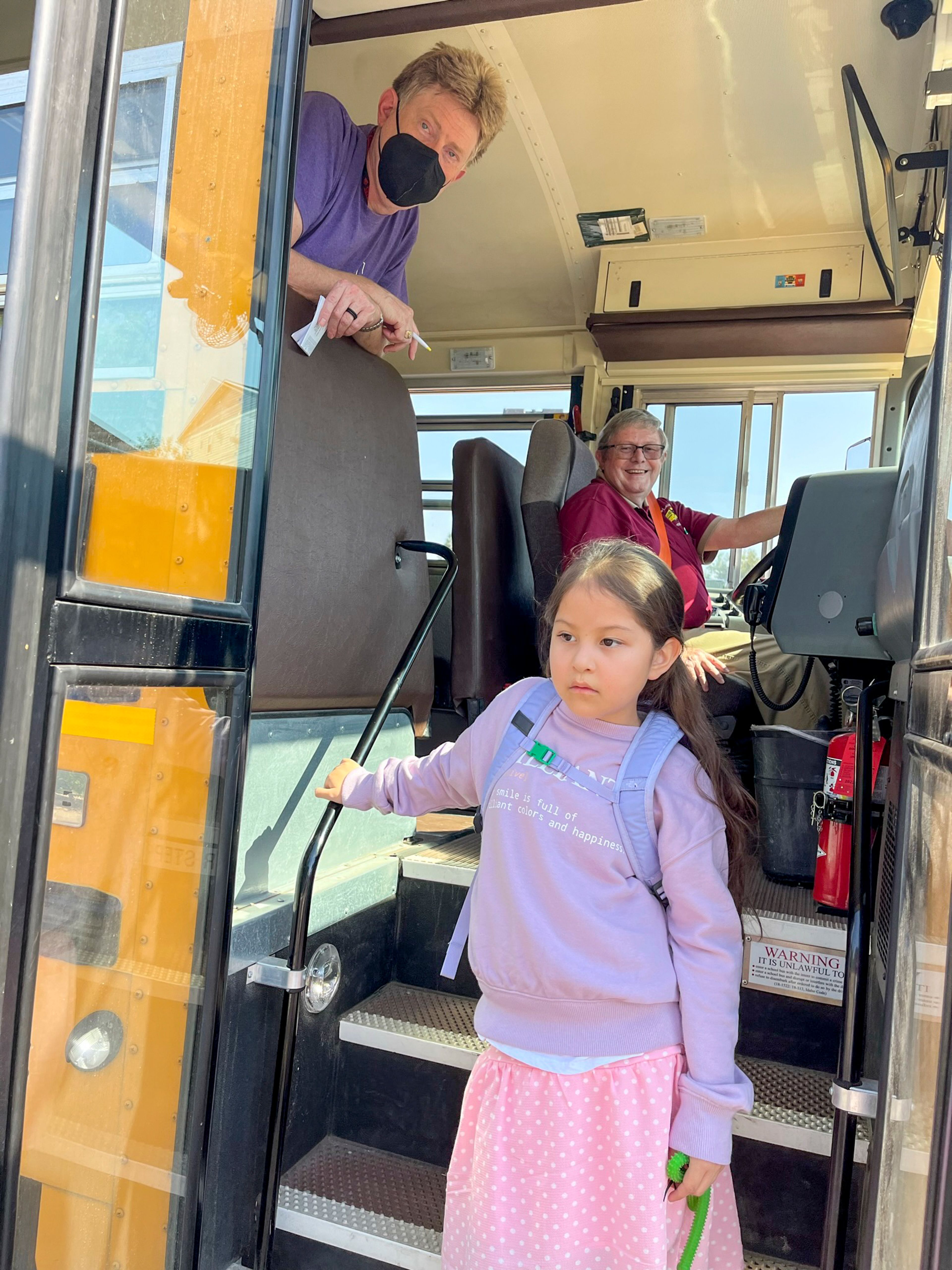 Bus drivers Ken Nuhn and Jay Dearien pose for a photograph with Laren Paul, 8, after school in Moscow. Nuhn and Dearien have taken the time to learn and greet Laren in the Nez Perce language upon pickup and drop-off from school.