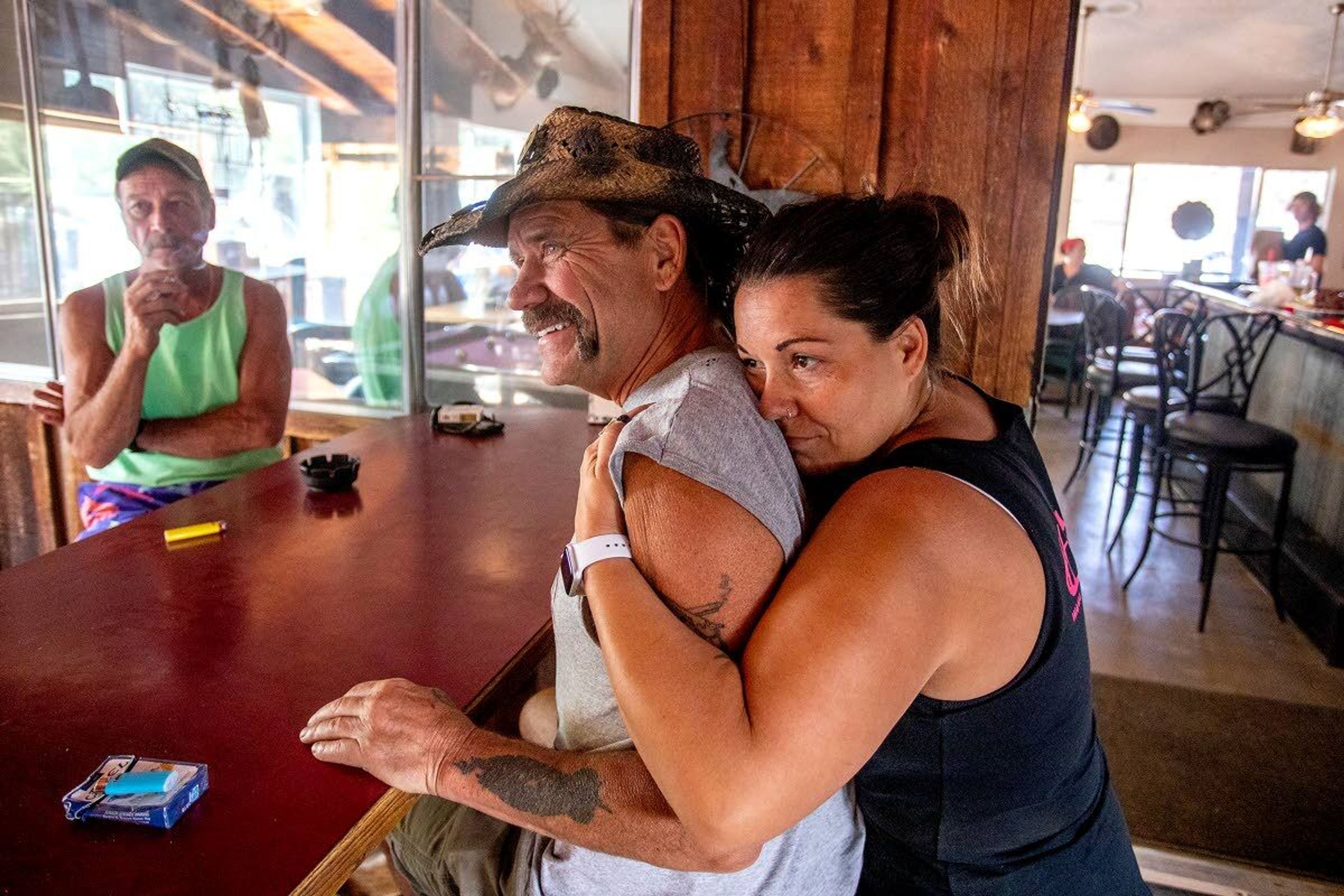 Sharon Barber embraces her father Cory James as they prepare food and gather up donations of food and water at the Waha Bar and Grill on Saturday. James, who owns the Waha Bar and Grill, was forced to evacuate his home on Friday night as firefighters continued to battle fires in the area including the Captain John Creek fire and Snake River Complex fire.