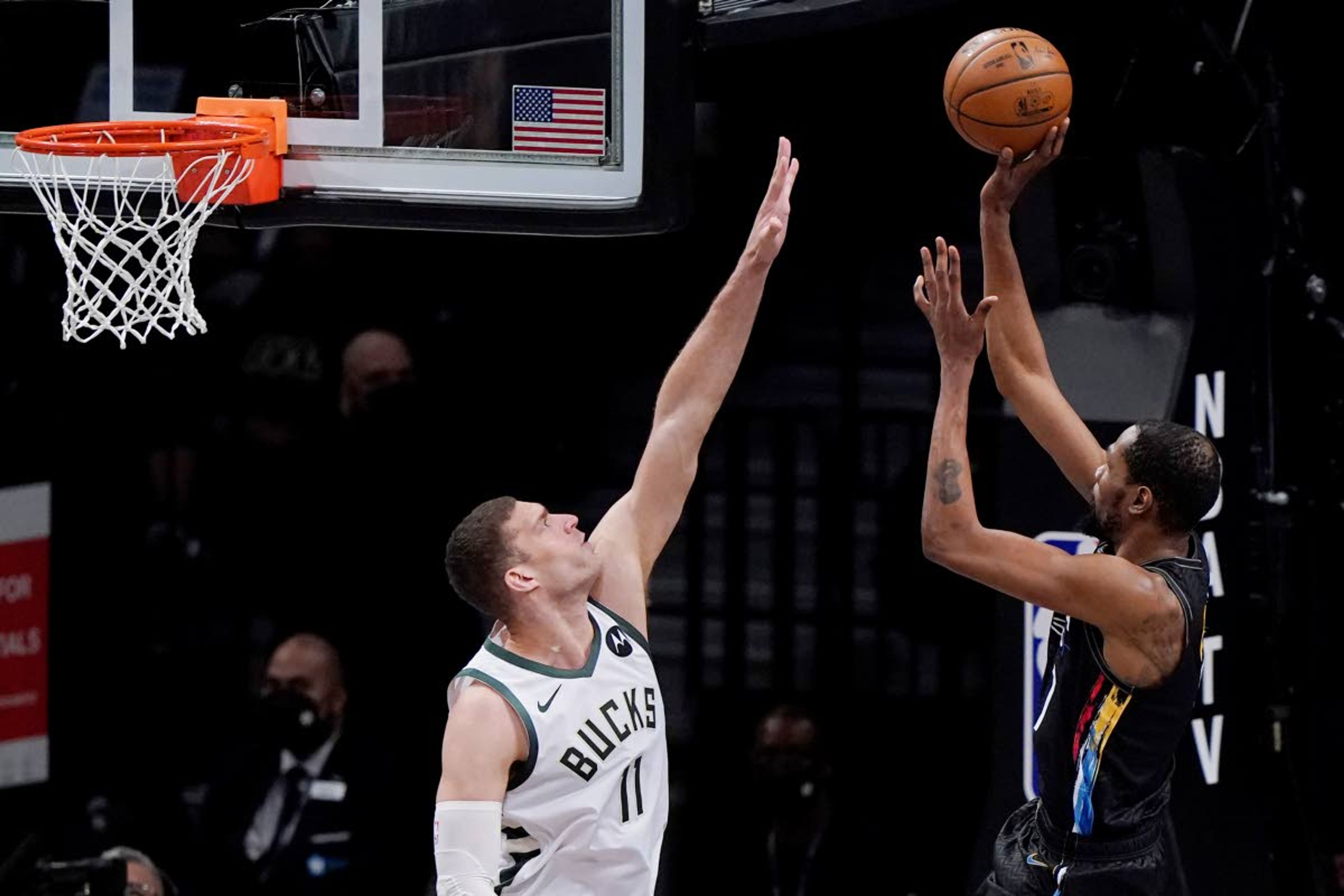 Milwaukee Bucks center Brook Lopez (11) defends as Brooklyn Nets forward Kevin Durant (7) shoots during the first half of Game 5 of a second-round NBA basketball playoff series Tuesday, June 15, 2021, in New York. (AP Photo/Kathy Willens)