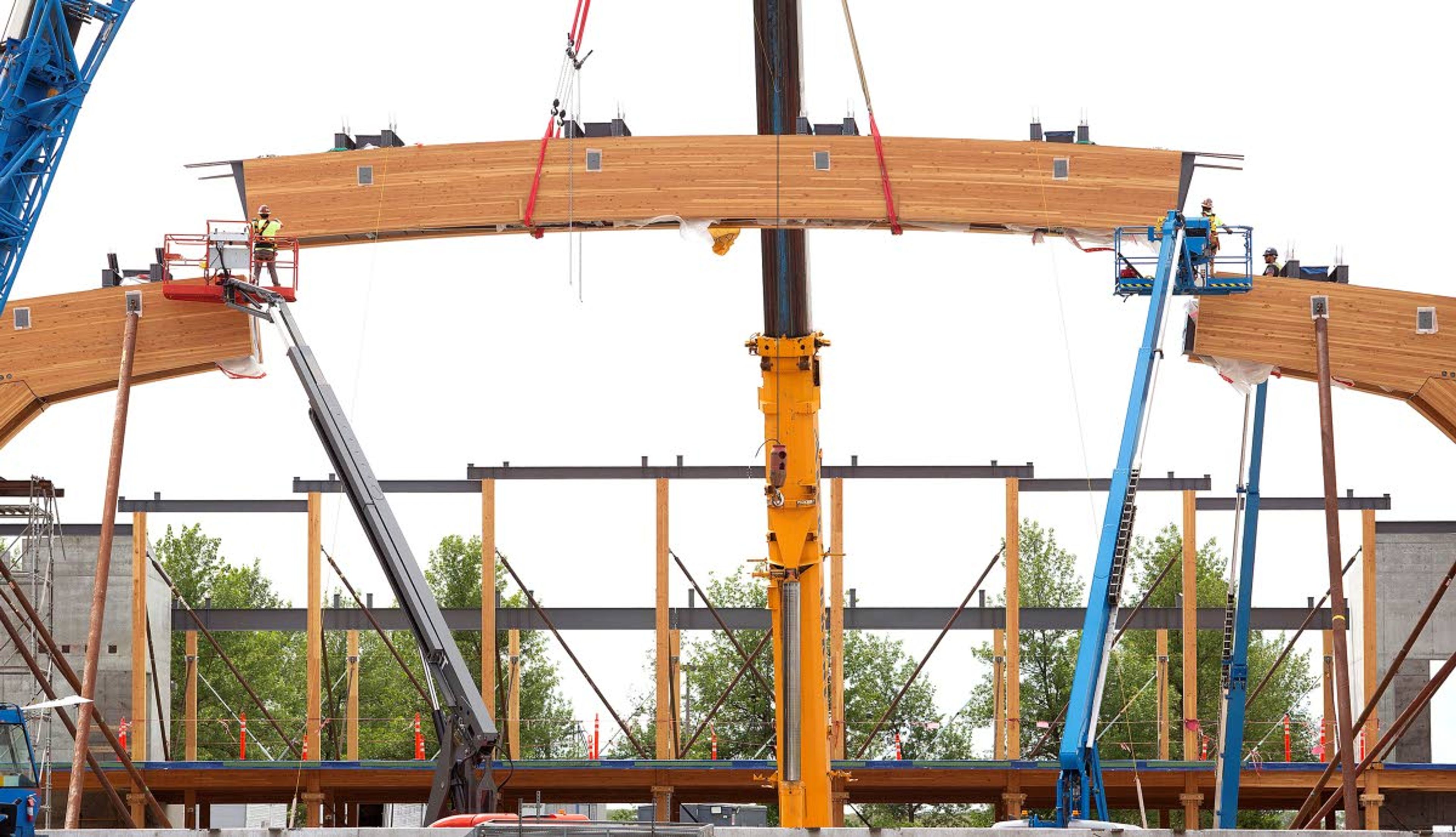 A laminated wood beam is lifted into place with a crane Wednesday at the Idaho Central Credit Union Arena at the University of Idaho in Moscow. The 60-foot-long beam weighs about 40,000 pounds. Arena construction is expected to be completed in September 2021.