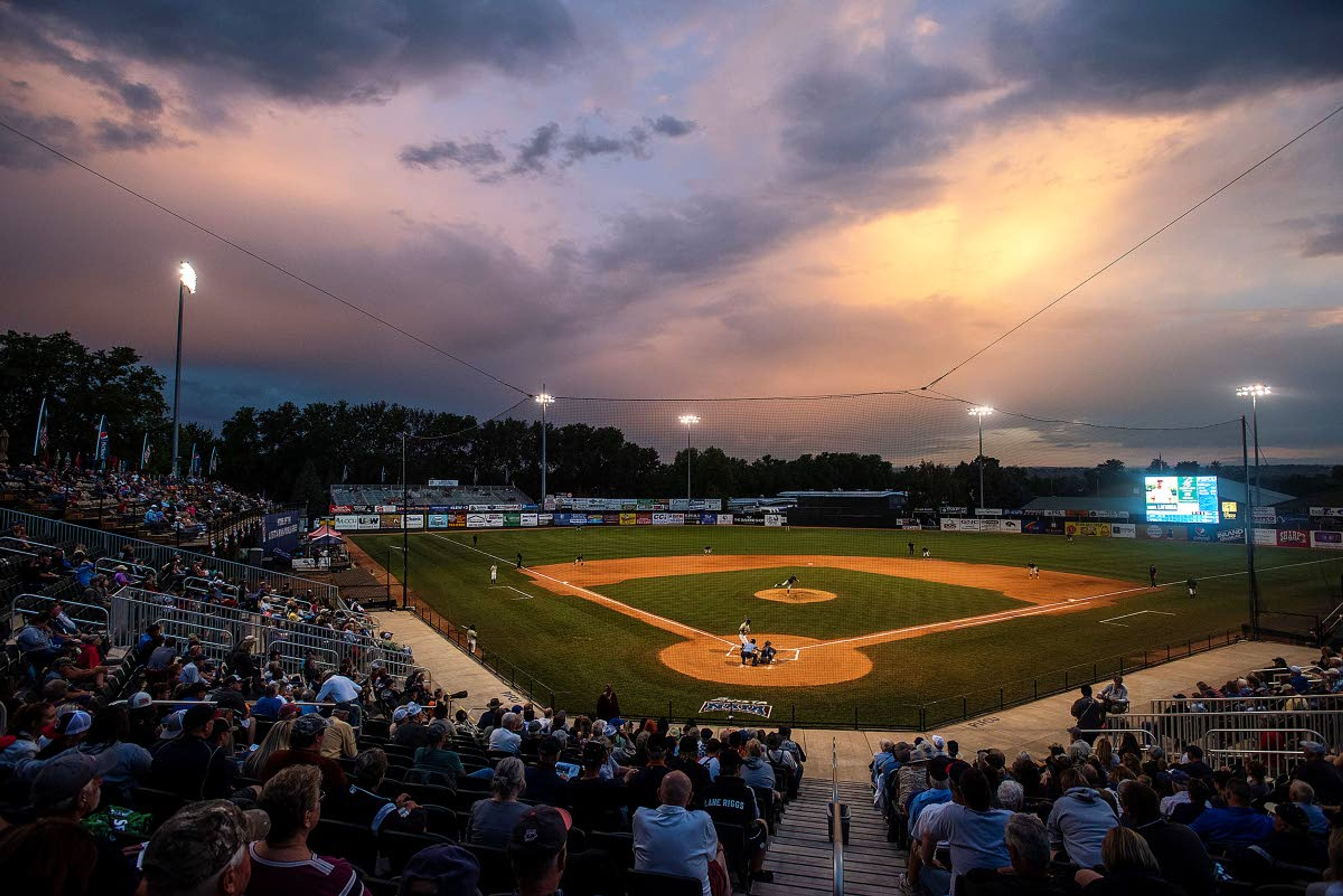 The setting sun paints storm clouds skirting the south end of Harris Field duringgame 18 of the NAIA World Series between St. Thomas and Science & Arts on Thursday at Harris Field in Lewiston.