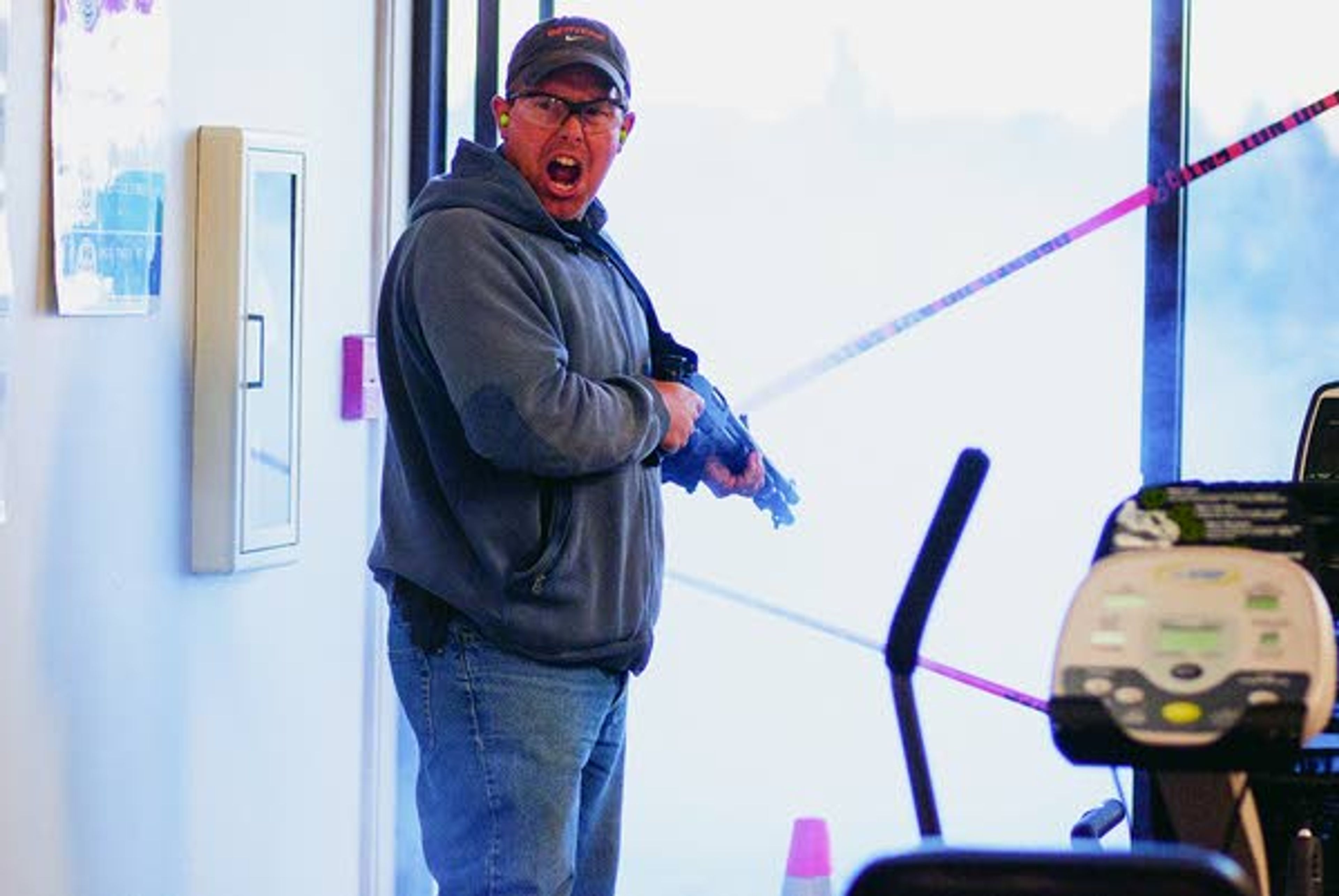 Against a cloud of burnt gunpowder, The "shooter," played by Pullman Police Department officer Aaron Breshears, terrorizes employees and patients in the Summit Therapy exercise area during an active shooter response drill run by the PPD on Sunday in Pullman.