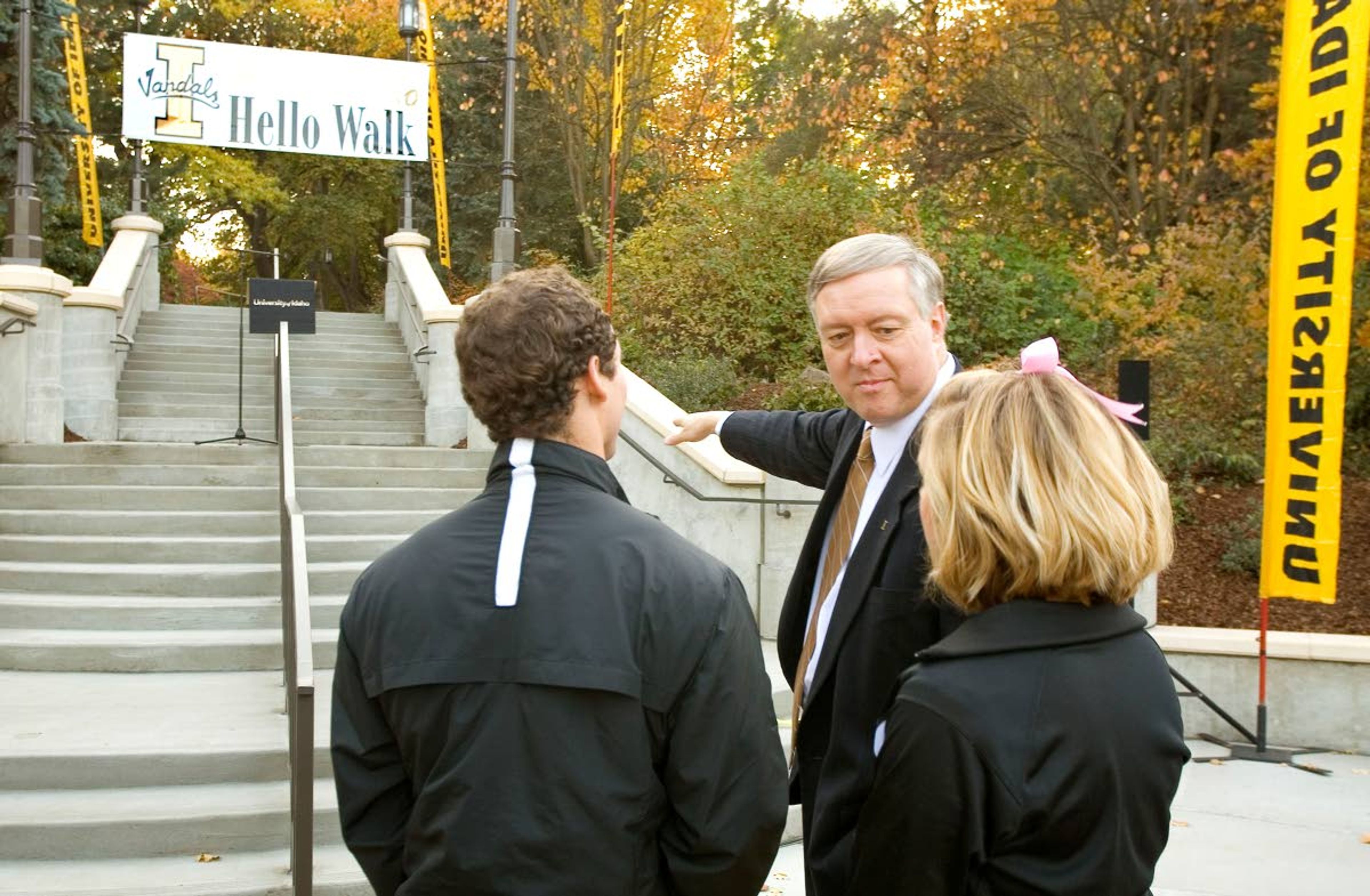 In this 2011 file photo, University of Idaho President Duane Nellis, center, talks with cheerleaders Aaron Cloud, left, and Kelsea Breton after the dedication of the new entrance to the Hello Walk on campus on Thursday. The Hello Walk runs diagonally from the Administration Building to Elm Street. It was named in 1920 by UI President Alfred Upham.