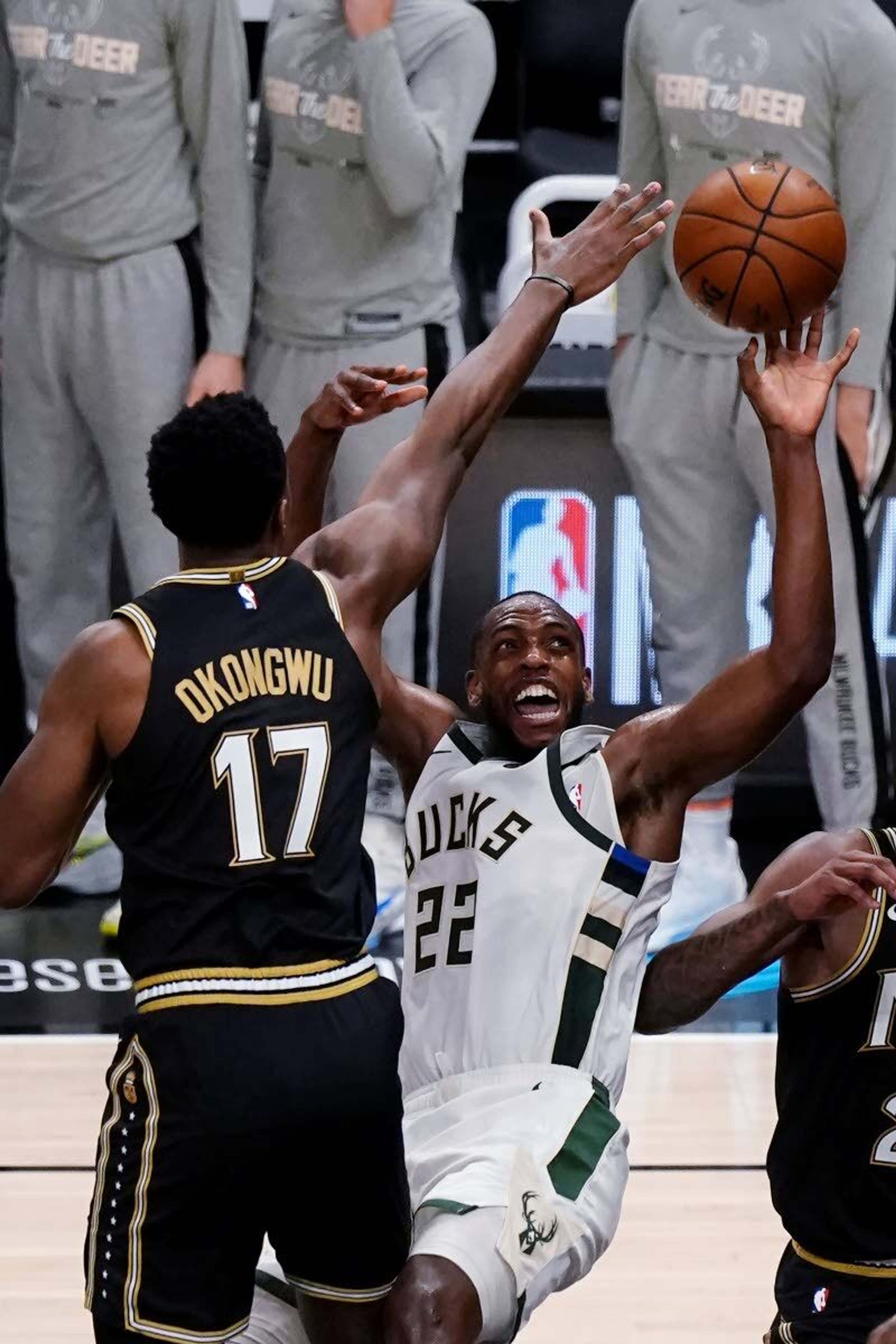 Milwaukee Bucks forward Khris Middleton (22) is fouled by Atlanta Hawks forward Onyeka Okongwu (17) during the second half of Game 6 of the Eastern Conference finals in the NBA basketball playoffs Saturday, July 3, 2021, in Atlanta. (AP Photo/John Bazemore)