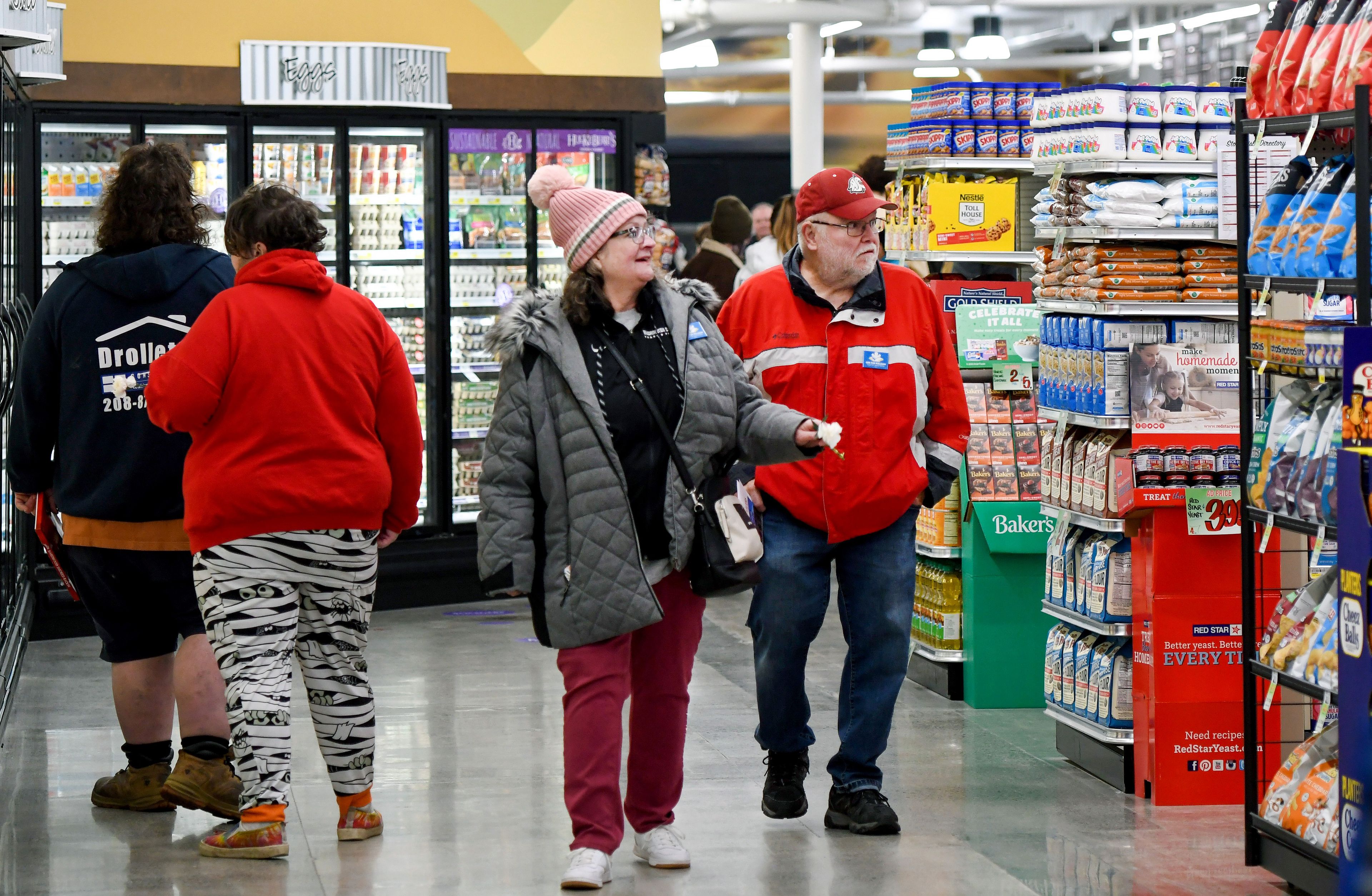 Pullman residents Deb McNeil, center, and Jack McGrath, right, walk through the new Rosauers along North Grand Avenue during the store’s grand opening event on Wednesday.