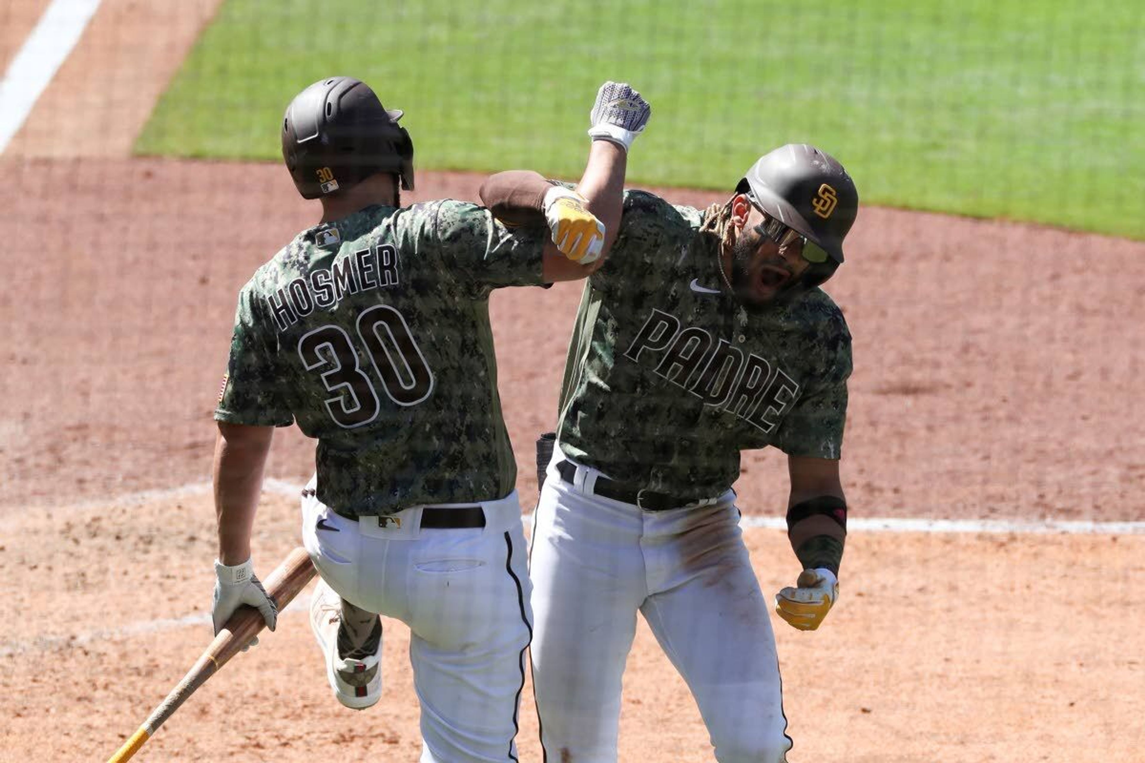 San Diego Padres' Fernando Tatis Jr., right, celebrates with Eric Hosmer (30) after hitting a grand slam off Seattle Mariners relief pitcher Robert Dugger in the seventh inning of a baseball game Sunday, May 23, 2021, in San Diego. (AP Photo/Derrick Tuskan)